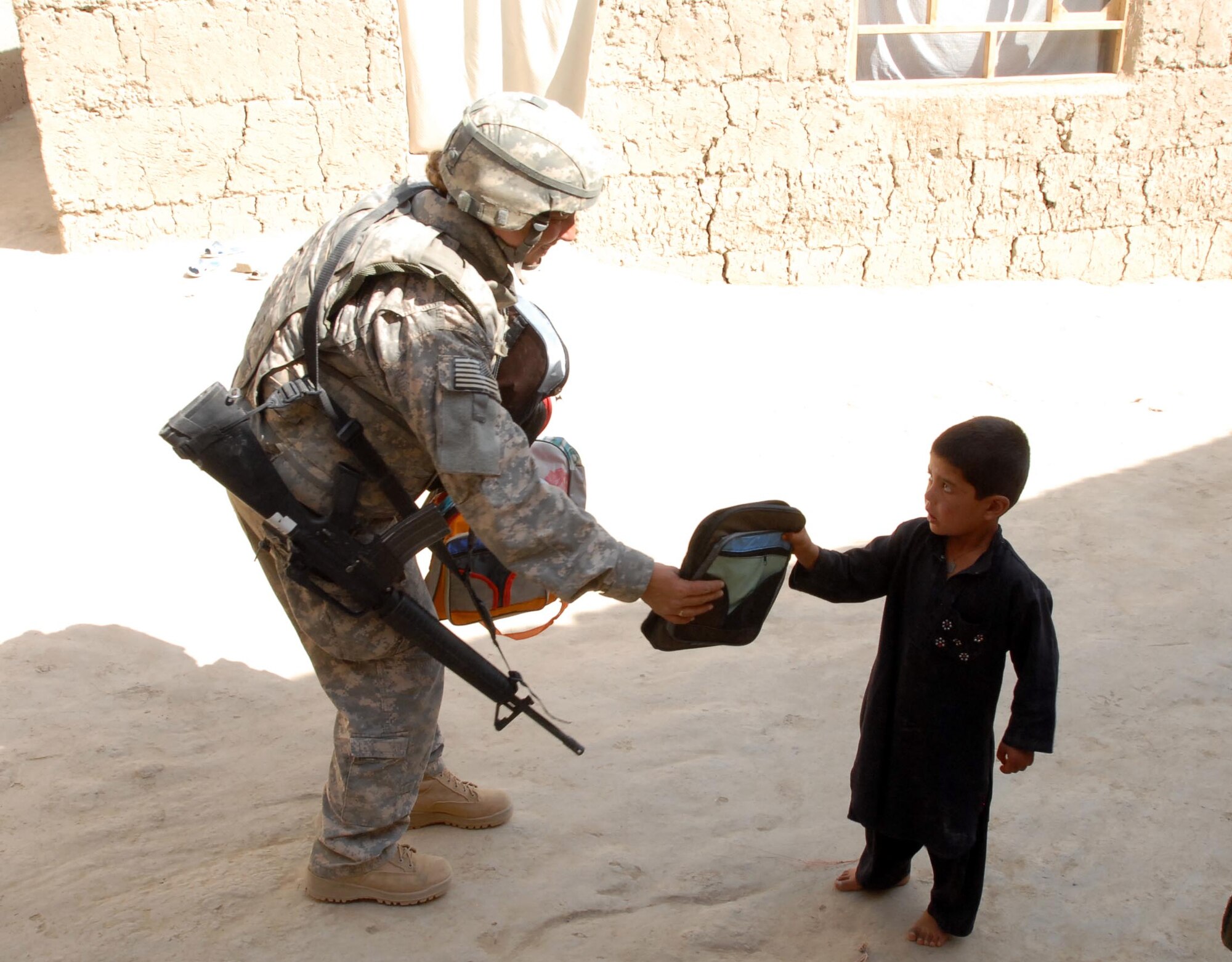 LOGAR PROVINCE, Afghanistan - Tech. Sgt. Michelle Stokes, counter improvised explosive device team, operating out of Forward Operating Base Shank distributes school supplies to children in the village of Polerad, Logar Province Afghanistan. (U.S. Army photo/Pfc. Melissa Stewart)