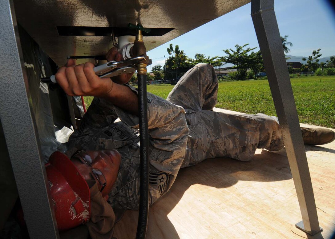 PADANG, Indonesia -- Staff Sgt. Thomas Agee connects a pump to a shower kit to provide running water  to a U.S. Air Force humanitarian assistance rapid response team Oct. 9. Sergeant Agee is a structural journeyman from the 554th RED HORSE Squadron at Andersen Air Force Base, Guam, and is deployed here with the HARRT.  The squadron provides the Air Force with a highly mobile civil engineering response force to support contingency and special operations worldwide. (U.S. Air Force photo/Staff Sgt. Veronica Pierce)