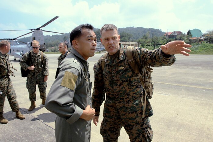 Col. Paul L. Damren, commanding officer of the 31st Marine Expeditionary Unit, and Col. Domingo B. Palisoc, commanding officer of 1st Air Division Philippine Air Force, talk about landing logistics disaster relief effort at Loakan Airport in Baguio City, Philippines, Oct. 11. Marines delivered nearly 4,500 family food packets and 2,000 clothing packages via five CH-46 Sea Knight helicopters.