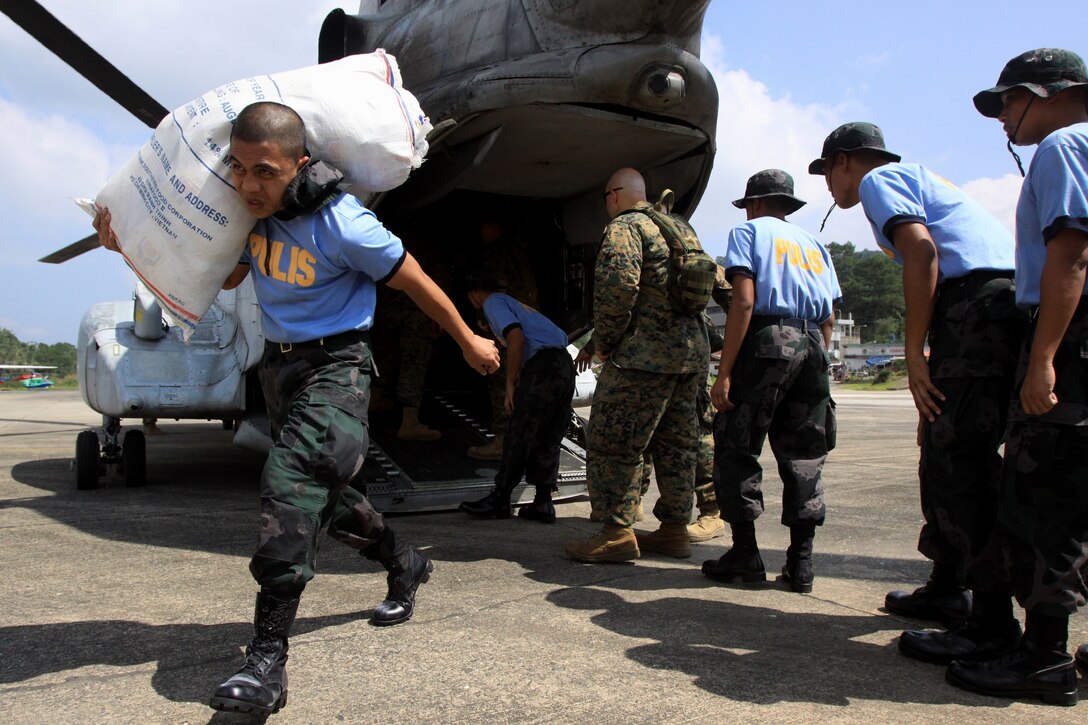 U.S. Marines and Philippine police load food and clothing onto a truck at Loakan Airport in Baguio City, Philippines, Oct. 11. Once the trucks were loaded they were then driven to a nearby warehouse, where they will be divided and shipped to nearby neighboring cities. Cities surrounding Baguio experienced severe landslides as a result of heavy rainfall from typhoon Parma.