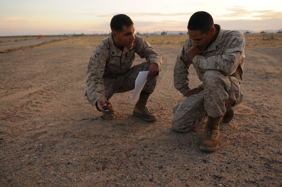 Cpl. Corey C. Haeuplte, squad leader with E Company, 2nd Battalion, 7th Marine Regiment, briefs one of his rifle team leaders Cpl. Joshua Diaz near the flight line at the Marine Corps Air Station in Yuma, Ariz., before a helicopter raid training exercise Oct. 10, 2009. Loading on to MV-22 Osprey aircraft in Yuma, the company's 1st Platoon flew to an urban training range in Twentynine Palms, Calif., in order to capture an insurgent leader, simulating a mission they could be called to perform during their next deployment. The battalion, based in Twentynine Palms, is scheduled to deploy with the 31st Marine Expeditionary Unit in early 2010, with E Company assigned to specialize in helicopter insertions and raids. Haeuplte, 23, is a native of Smyrna, Tenn., and Diaz, 21, is a native of Long Beach, Calif.