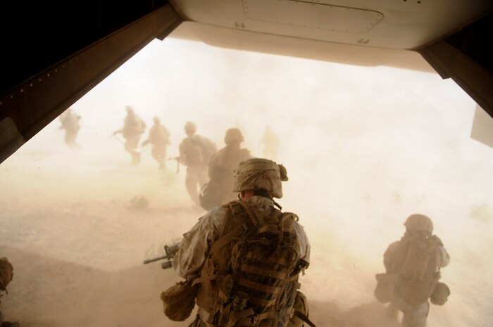 Marines with E Company, 2nd Battalion, 7th Marine Regiment, storm from the back of an MV-22 Osprey into a disorienting cloud of sand kicked up by powerful rotor wash on the outskirts of an urban training range in Twentynine Palms, Calif., on Oct. 10, 2009. The battalion, based in Twentynine Palms, is scheduled to deploy with the 31st Marine Expeditionary Unit in early 2010, with E Company assigned to specialize in helicopter insertions and raids.