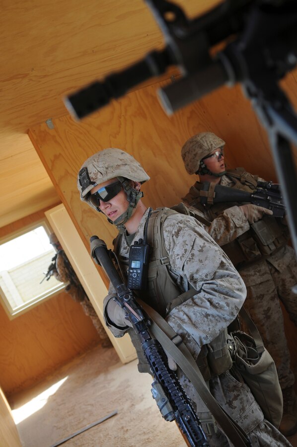 Lance Cpl. Michael R. Gravitt, rifle team leader, along with other members of with E Company, 2nd Battalion, 7th Marine Regiment, keep watch on the doors and windows of a building they just cleared in an urban training range in Twentynine Palms, Calif., on Oct. 10, 2009. The company's 1st Platoon flew from the Marine Corps Air Station in Yuma, Ariz, to Twentynine Palms, Calif., in order to raid a town and capture an insurgent leader, simulating a mission they could be called to perform during their next deployment. The battalion, based in Twentynine Palms, is scheduled to deploy with the 31st Marine Expeditionary Unit in early 2010, with E Company assigned to specialize in helicopter insertions and raids. Gravitt, 20, is a native of Moline, Ill.