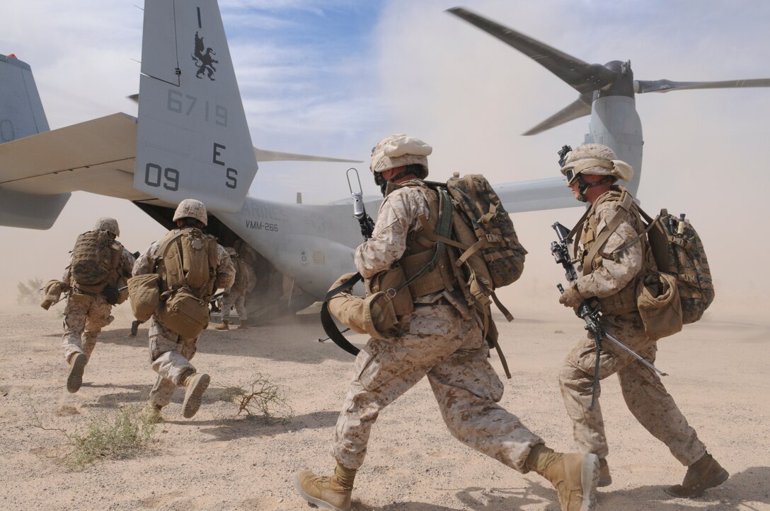 Members of E Company, 2nd Battalion, 7th Marine Regiment, run into the back of an MV-22 Osprey outside of an urban training range in Twentynine Palms, Calif., on Oct. 10, 2009. The company's 1st Platoon flew from the Marine Corps Air Station in Yuma, Ariz, to Twentynine Palms, Calif., in order to raid a town and capture an insurgent leader, simulating a mission they could be called to perform during their next deployment. The battalion, based in Twentynine Palms, is scheduled to deploy with the 31st Marine Expeditionary Unit in early 2010, with E Company assigned to specialize in helicopter insertions and raids.