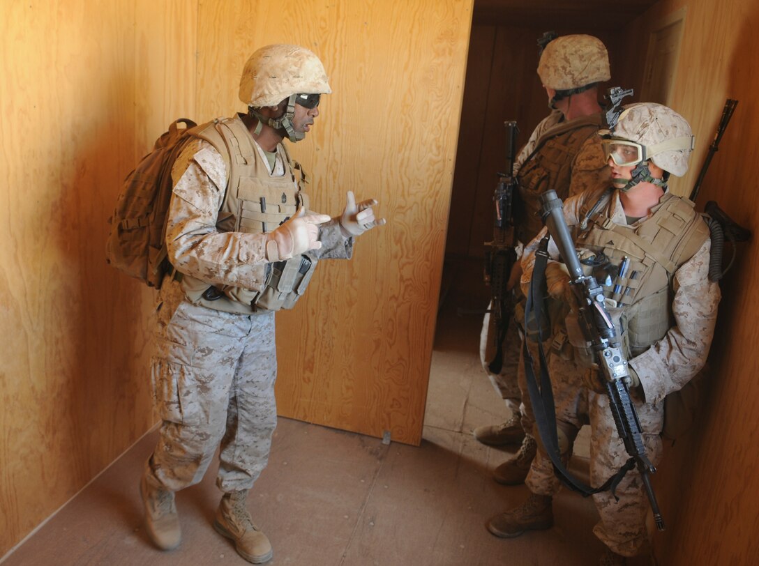 Gunnery Sgt. Jomoore K. Toney, company gunnery sergeant for E Company, 2nd Battalion, 7th Marine Regiment, stops Lance Cpl. Matt P. Owens, rifleman and radio operator, to remind him of some basic urban warfare tactics during a raid exercise in a mock town at Twentynine Palms, Calif., on Oct. 10, 2009. The company's 1st Platoon flew from the Marine Corps Air Station in Yuma, Ariz, to Twentynine Palms, Calif., in order to raid a town and capture an insurgent leader, simulating a mission they could be called to perform during their next deployment. The battalion, based in Twentynine Palms, is scheduled to deploy with the 31st Marine Expeditionary Unit in early 2010, with E Company assigned to specialize in helicopter insertions and raids. Toney, 34, is a native of Corpus Christi, Texas, and Owens, 19, is a native of Bismark, Ill.