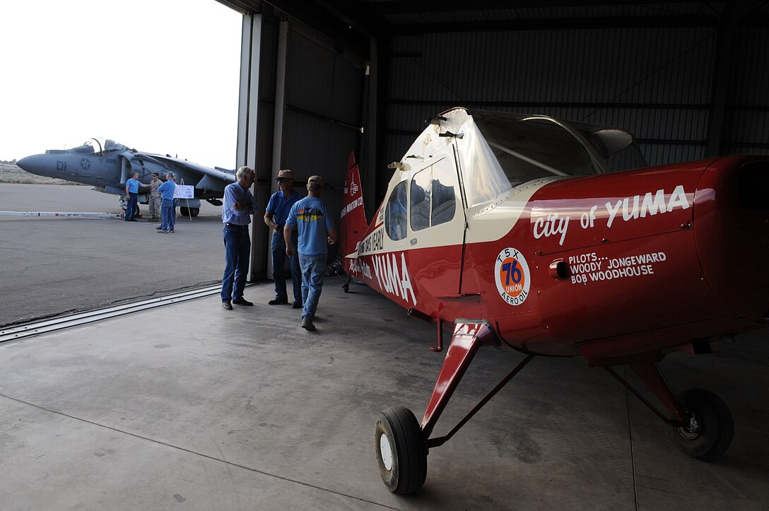 Attendees at the endurance flight anniversary breakfast observe the historic plane, the City of Yuma, as well as an AV-8B Harrier from Marine Attack Squadron 211, Oct. 10, 2009, at the Yuma International Airport in Yuma, Ariz., during the 60th anniversary of the plane's record-breaking, 47-day nonstop flight. Woody Jongeward, one of the two City of Yuma endurance flight pilots, attended the anniversary breakfast as the guest of honor. The flight took place in 1949, several years after the Army closed its air base on the land that became the Marine Corps Air Station in Yuma, Ariz.