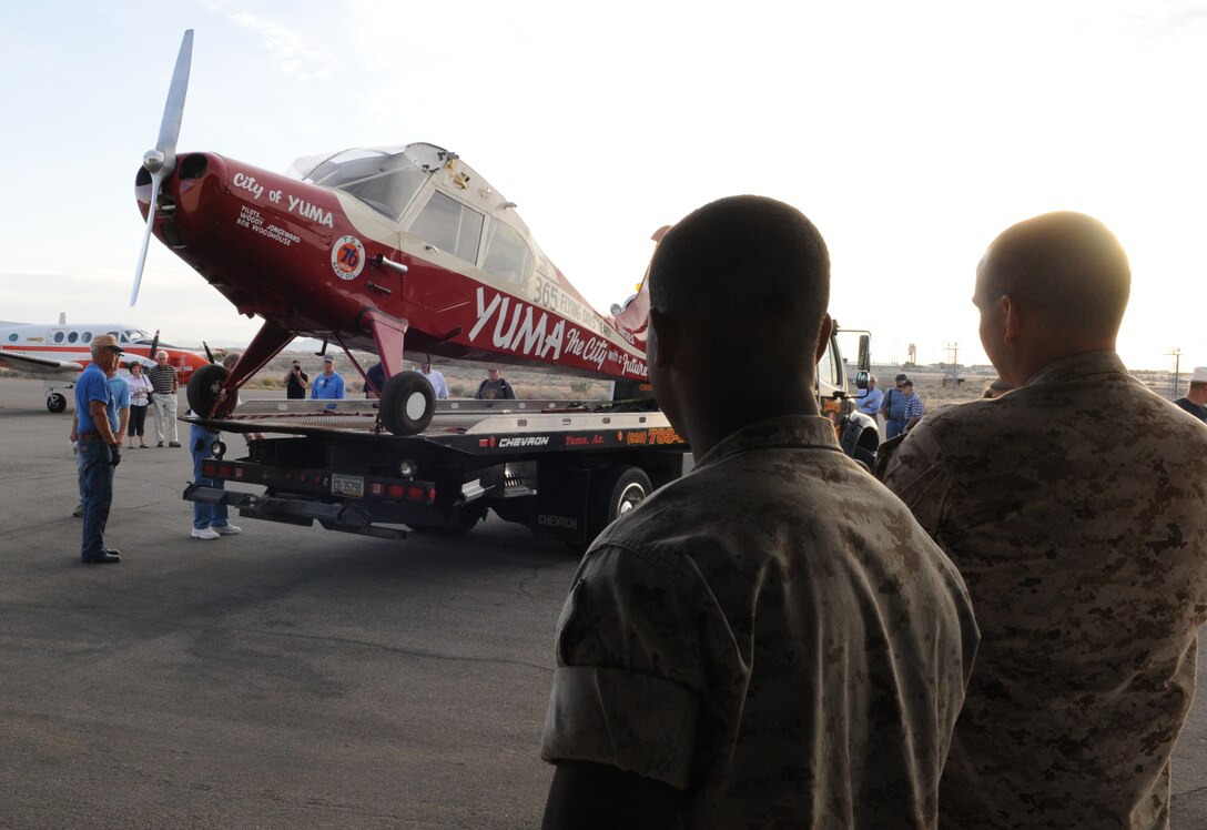 Cpl. Aaron Klopf, left, and Lance Cpl. Caleb Copper, air traffic control radar controllers, watch as the historic plane, the City of Yuma, is unloaded into the Lux Air hangar Oct. 10, 2009, at the Yuma International Ariport in Yuma, Ariz., for the 60th anniversary of the plane's record-breaking, 47-day nonstop flight. Woody Jongeward, one of the two City of Yuma endurance flight pilots, attended the anniversary breakfast as the guest of honor. The flight took place in 1949, several years after the Army closed its air base on the land that became the Marine Corps Air Station in Yuma, Ariz.