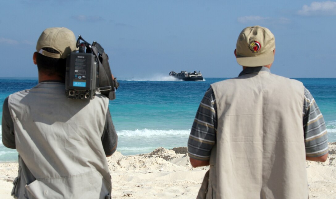Egyptian cameramen photograph and film a Landing Craft, Air-Cushioned, from Assault Craft Unit 4 as it approaches the beach during an offload for Exercise Bright Star 2009 in Egypt Oct. 10, 2009. The multinational exercise is designed to improve readiness, interoperability, and strengthen the military and professional relationships among U.S., Egyptian and participating forces. Bright Star is conducted by U.S. Central Command and held every two years. Elements of the 22nd MEU are currently are participating in the multi-national exercise while serving as the theater reserve force for U.S. Central Command.::r::::n::(Official Marine Corps photo by Cpl. Theodore W. Ritchie)::r::::n::