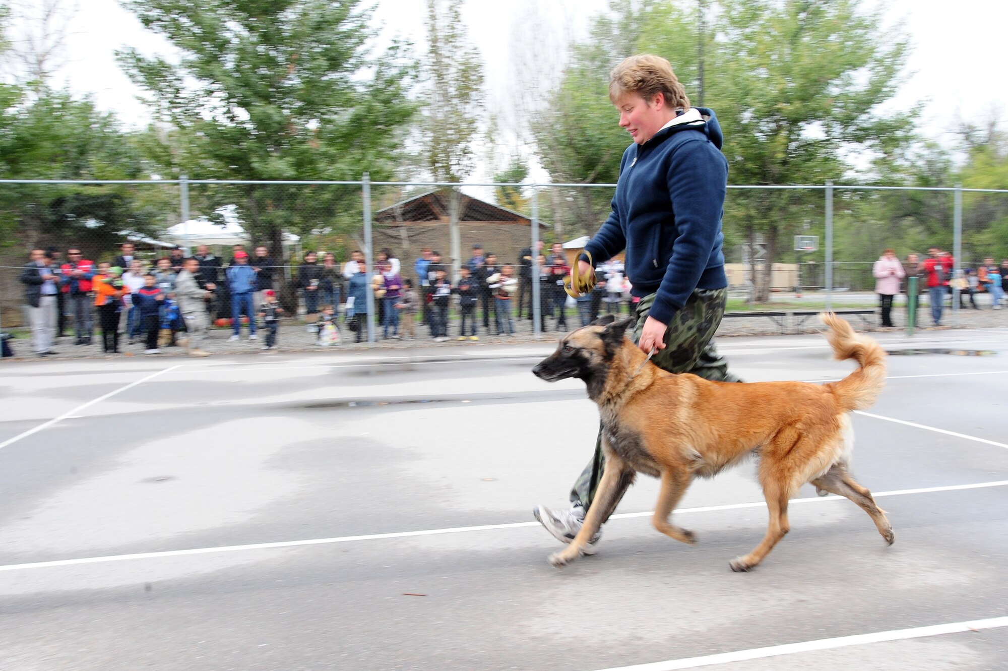 TRANSIT CENTER AT MANAS, Kyrgyzstan -- Maj. Natalia Balabrikova, Kyrgyzstan State Security Service K-9 Unit chief, displays techniques with her dog Volia for an audience during Friends and Family Day at the Transit Center, Oct. 5, 2009. The day consisted of static displays, games, face painting, live music, food and strengthened friendships between the U.S. military and the local community surrounding Manas.(U.S. Air Force photo/Senior Airman Steele C. G. Britton)