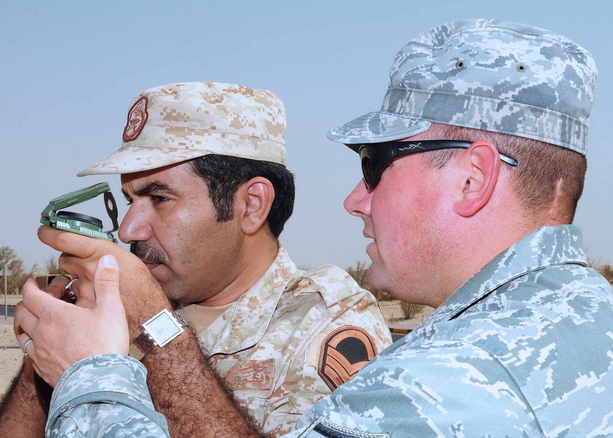 SOUTHWEST ASIA -- Master Sgt. Terry Meadows, 386th Expeditionary Security Forces Squadron host nation training non-commissioned officer in charge, shows a host nation security forces member how to read a compass to get the azimuth for left and right sectors of fire for their range cards during level-1 training at an undisclosed location in Southwest Asia Oct. 11, 2009.  Level-1 training is designed to strengthen the ground combat capability of host nation military forces.  Sergeant Meadows is deployed from the 14th Flying Training Wing, Columbus Air Force Base, Miss., and hails from Albuquerque, N.M.  (U.S. Air Force photo/Tech. Sgt. Tony Tolley)