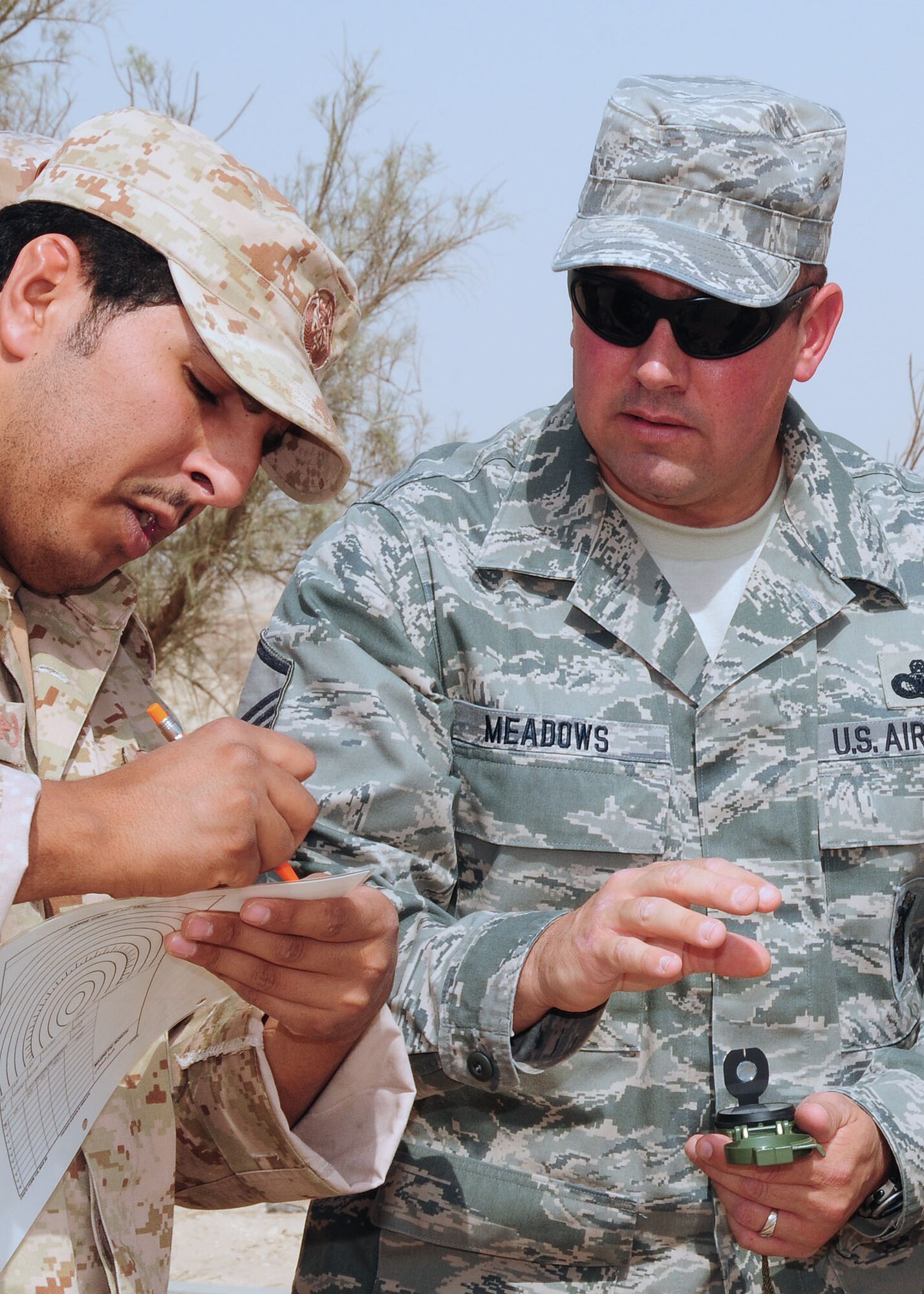 SOUTHWEST ASIA -- Master Sgt. Terry Meadows, 386th Expeditionary Security Forces Squadron host nation training non-commissioned officer in charge, shows a host nation security forces member how to use a compass to get the azimuth for left and right sectors of fire for their range cards during level-1 training at an undisclosed location in Southwest Asia Oct. 11, 2009.  Level-1 training is designed to strengthen the ground combat capability of host nation military forces.  Sergeant Meadows is deployed from the 14th Flying Training Wing, Columbus Air Force Base, Miss., and hails from Albuquerque, N.M.  (U.S. Air Force photo/Tech. Sgt. Tony Tolley)