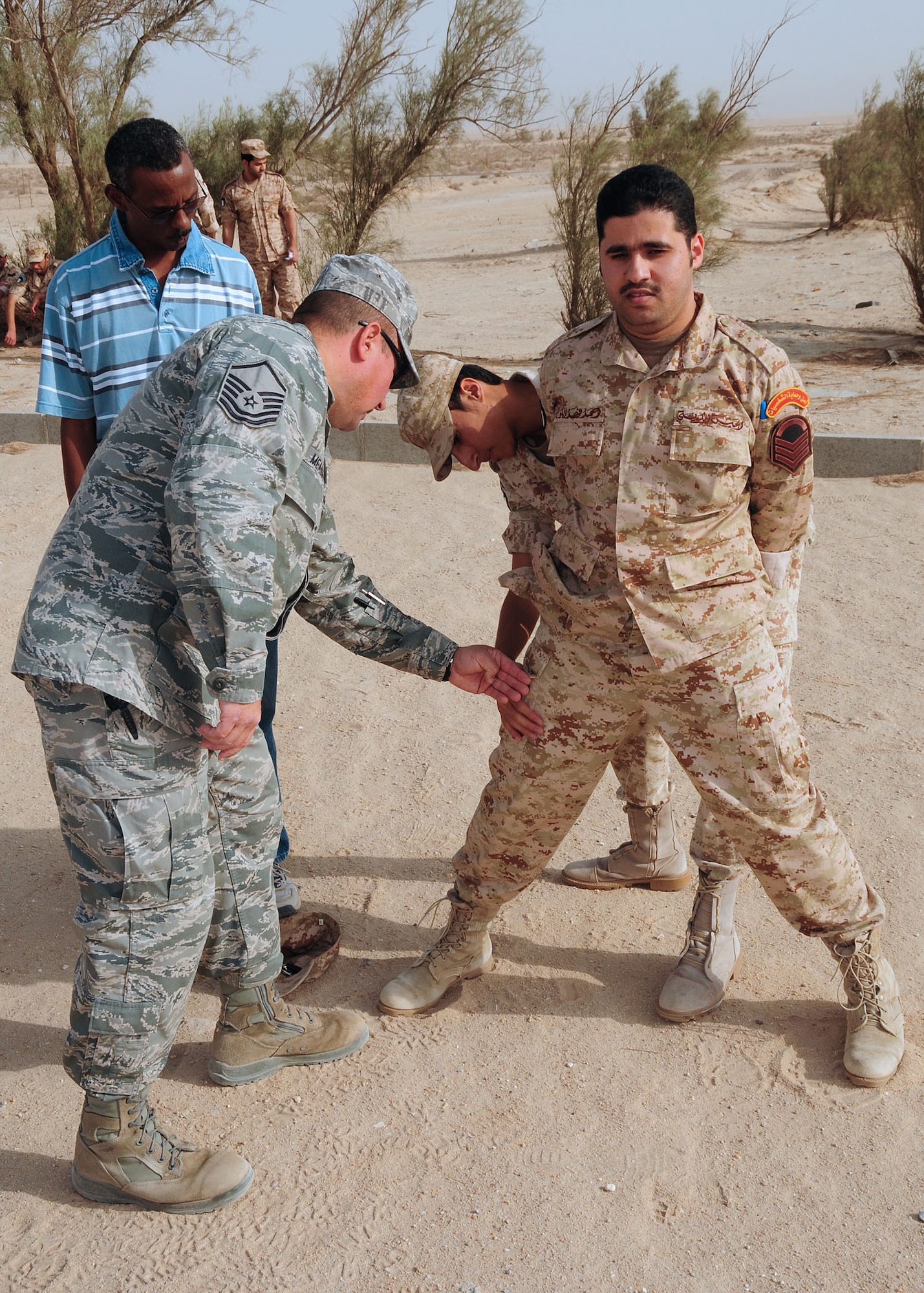 SOUTHWEST ASIA -- Master Sgt. Terry Meadows, 386th Expeditionary Security Forces Squadron host nation training non-commissioned officer in charge, shows a host nation security forces member how to search for objects on a member in handcuffs during Level-1 training at an undisclosed location in Southwest Asia Oct. 11, 2009.  Level-1 training is designed to strengthen the ground combat capability of host nation military forces.  Sergeant Meadows is deployed from the 14th Flying Training Wing, Columbus Air Force Base, Miss., and hails from Albuquerque, N.M.  (U.S. Air Force photo/Tech. Sgt. Tony Tolley)