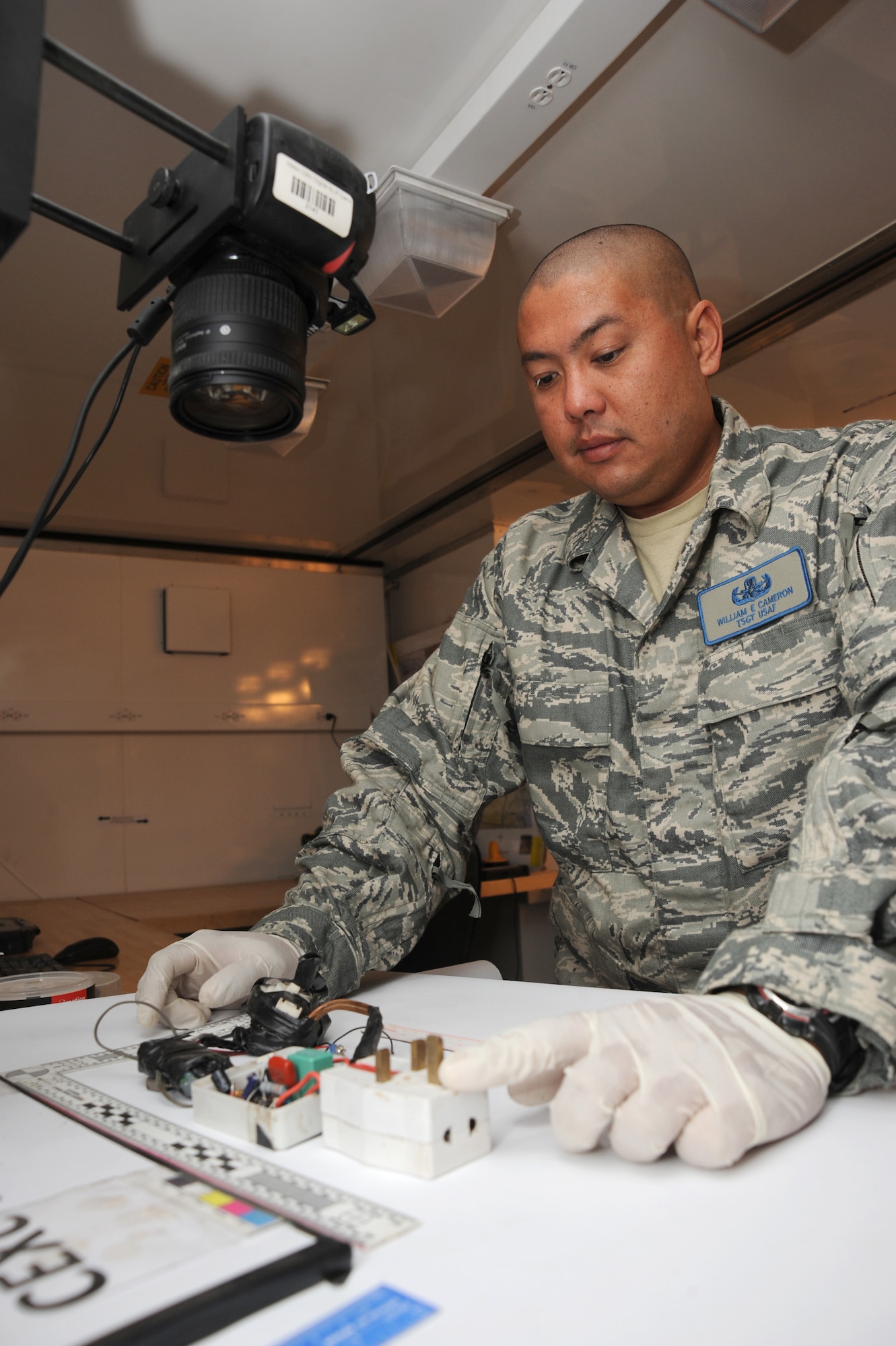 CAMP VICTORY, Iraq -- Air Force Tech. Sgt. William Cameron, Combined Joint Task Force Troy Combined Explosive Exploitation Cell Triage Lab noncommissioned officer in charge, documents evidence collected from an improvised explosive device here Oct. 10, 2009. Sergeant Cameron is an explosive ordnance disposal technician who ensures evidence components are safe to handle by removing hazardous materials. This allows Functional Analysis Cell members to safely analyze evidence and piece together a true picture of the IED threat in Iraq. Sergeant Cameron is deployed from Detachment 63, Indian Head Naval Ordnance Station, Md., and hails from Middleburg, Fla. (U.S. Air Force photo/Tech. Sgt. Johnny L. Saldivar)