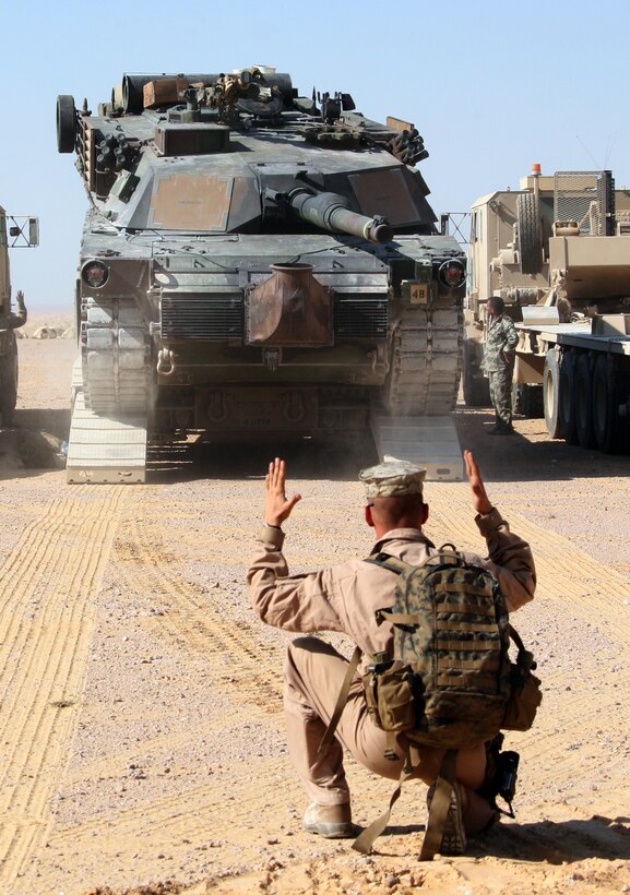 A Marine from India Company, Battalion Landing Team, 3rd Battalion, 2nd Marine Regiment, 22nd Marine Expeditionary Unit, guides an M1-A1 Abrams Main Battle Tank off a transport trailer at a bivouac site during Exercise Bright Star 2009 in Egypt Oct. 11, 2009. The multinational exercise is designed to improve readiness, interoperability, and strengthen the military and professional relationships among U.S., Egyptian and participating forces. Bright Star is conducted by U.S. Central Command and held every two years. Elements of the 22nd MEU are currently are participating in the multi-national exercise while serving as the theater reserve force for U.S. Central Command.::r::::n::(Official Marine Corps photo by Cpl. Theodore W. Ritchie)::r::::n::