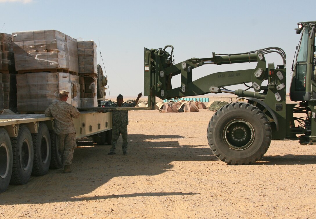 An Egyptian service member guides a forklift from Combat Logistics Battalion 22, 22nd Marine Expeditionary Unit, as it unloads pre-packaged meals at a bivouac site during Exercise Bright Star 2009 in Egypt Oct. 11, 2009. The multinational exercise is designed to improve readiness, interoperability, and strengthen the military and professional relationships among U.S., Egyptian and participating forces. Bright Star is conducted by U.S. Central Command and held every two years. Elements of the 22nd MEU are currently are participating in the multi-national exercise while serving as the theater reserve force for U.S. Central Command.::r::::n::(Official Marine Corps photo by Cpl. Theodore W. Ritchie)::r::::n::