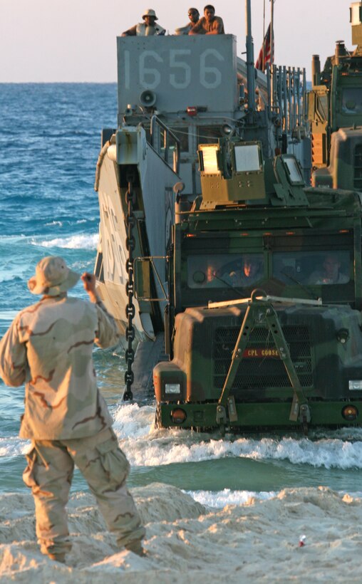 A naval beach master guides a 7-ton truck from 22nd Marine Expeditionary Unit off a Landing Craft Utility during Exercise Bright Star 2009 in Egypt Oct. 11, 2009. The multinational exercise is designed to improve readiness, interoperability, and strengthen the military and professional relationships among U.S., Egyptian and participating forces. Bright Star is conducted by U.S. Central Command and held every two years. Elements of the 22nd MEU are currently are participating in the multi-national exercise while serving as the theater reserve force for U.S. Central Command.::r::::n::(Official Marine Corps photo by Cpl. Theodore W. Ritchie)::r::::n::