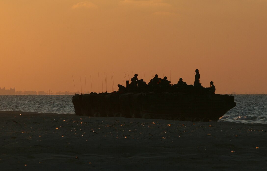 Silhouetted by the setting-sun, Marines from Amphibious Assault Vehicle Platoon, India Company, Battalion Landing Team, 3rd Battalion, 2nd Marine Regiment, 22nd Marine Expeditionary Unit, take a break after coming ashore during Exercise Bright Star 2009 in Egypt Oct. 11, 2009. The multinational exercise is designed to improve readiness, interoperability, and strengthen the military and professional relationships among U.S., Egyptian and participating forces. Bright Star is conducted by U.S. Central Command and held every two years. Elements of the 22nd MEU are currently are participating in the multi-national exercise while serving as the theater reserve force for U.S. Central Command.::r::::n::(Official Marine Corps photo by Cpl. Theodore W. Ritchie)::r::::n::