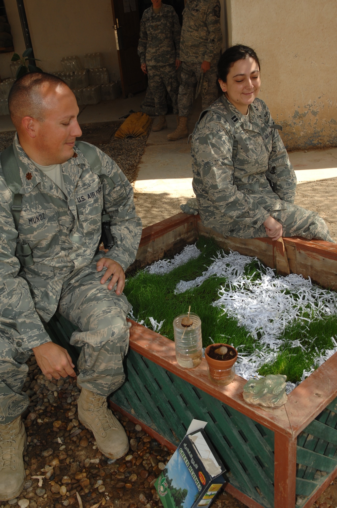 CAMP TAJI, Iraq – Maj. Derek Munoz, 332nd Air Expeditionary Wing psychologist, and Capt. Joy Jones, 332nd AEW psychiatrist, sit by a patch of grass cultivated by mental health technicians here outside the combat stress clinic Oct. 7, 2009. The Airmen are two of the four 332nd AEW mental health professionals embedded with the Army’s 55th Medical Company. (U.S. Air Force photo/ Senior Airman Andria J. Allmond)
