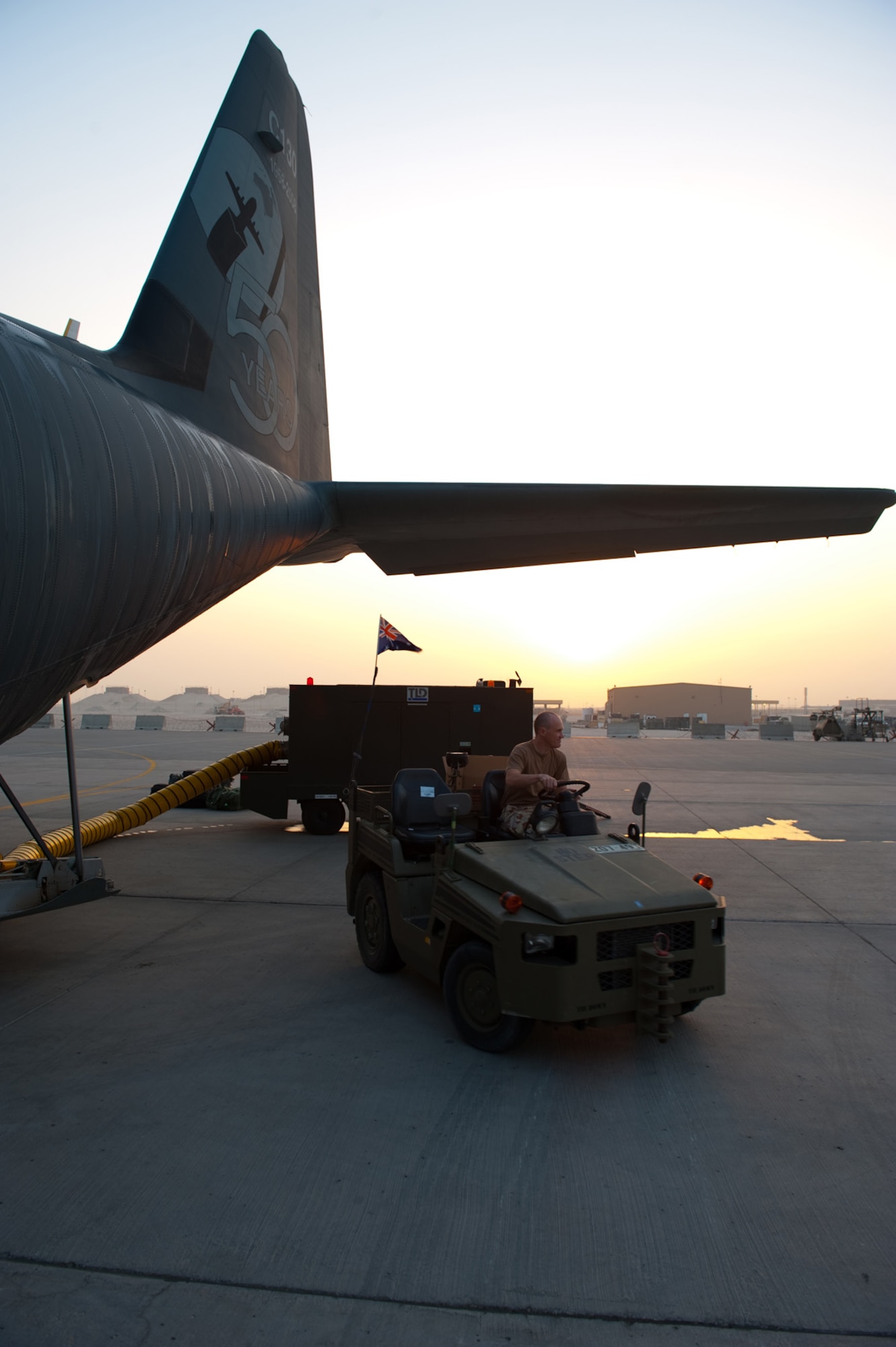 Royal Australian Air Force Sergeant James Bennett, No. 37 Squadron avionics technician, positions an air-conditioning unit as the crew prepares a C-130J for departure, Oct. 11, in Southwest Asia. The 37 Squadron C-130Js provide intra-theater combat airlift support throughout Southwest Asia in support of Australian and allied forces. Sergeant Bennett is deployed from RAAF Base Richmond, Australia, in support of Operation Slipper, Australian's military contribution to international campaigns against terrorism. (U.S. Air Force photo/Staff Sgt. Robert Barney) 