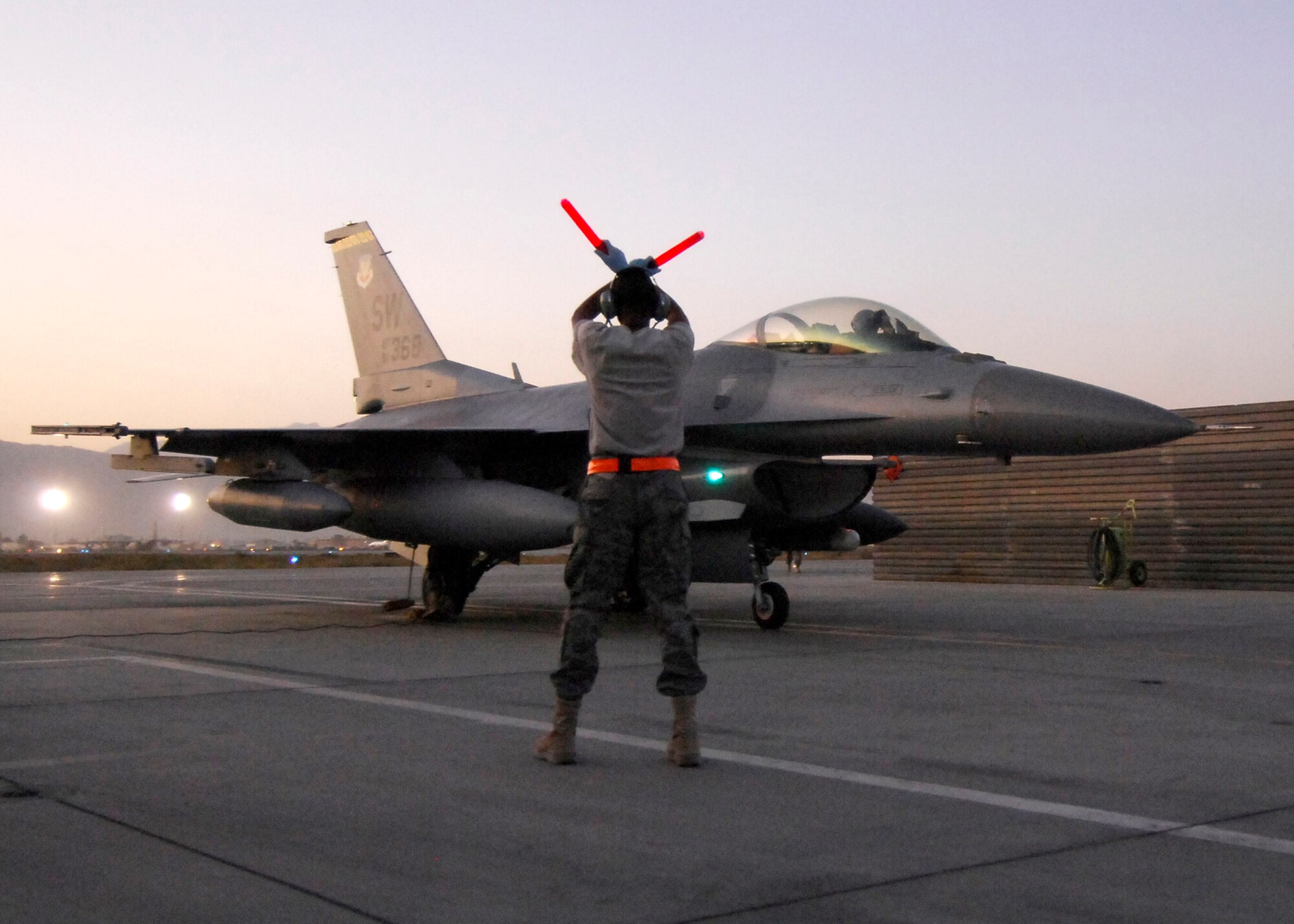 BAGRAM AIRFIELD, Afghanistan -- Airman First Class Elbert Thompson, an assistant dedicated crew chief from the 79th Expeditionary Fighter Squadron, halts an F-16 Fighting Falcon in its designated parking spot after receiving an inspection here, Oct. 11, 2009.  The aircraft receive inspections before takeoff and after landing to ensure the safety of the aircraft and pilot.  Airman Thompson, a Mobile, Ala. native, is deployed from Shaw Air Force Base, S.C.  (U.S. Air Force photo/Senior Airman Felicia Juenke)