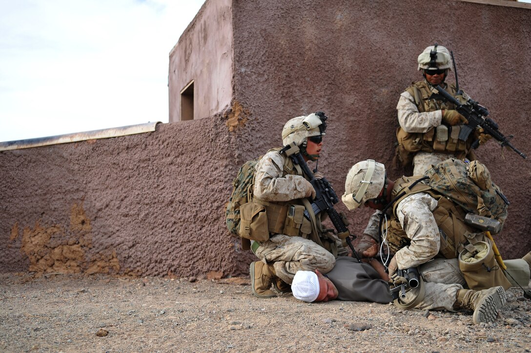 2nd Lt. Lucky Prak, 2nd platoon commander, right, watches as two Marines from E Company, 2nd Battalion, 7th Marine Regiment, detain role player Lance Cpl. Timothy Buckley during a helicopter-borne raid on a mock Middle Eastern village on U.S. Army Yuma Proving Ground, Oct. 12, 2009. The Marines landed in four different locations via UH-1N Huey helicopters around the area with the intent to clear the town and extract three high-value individuals.