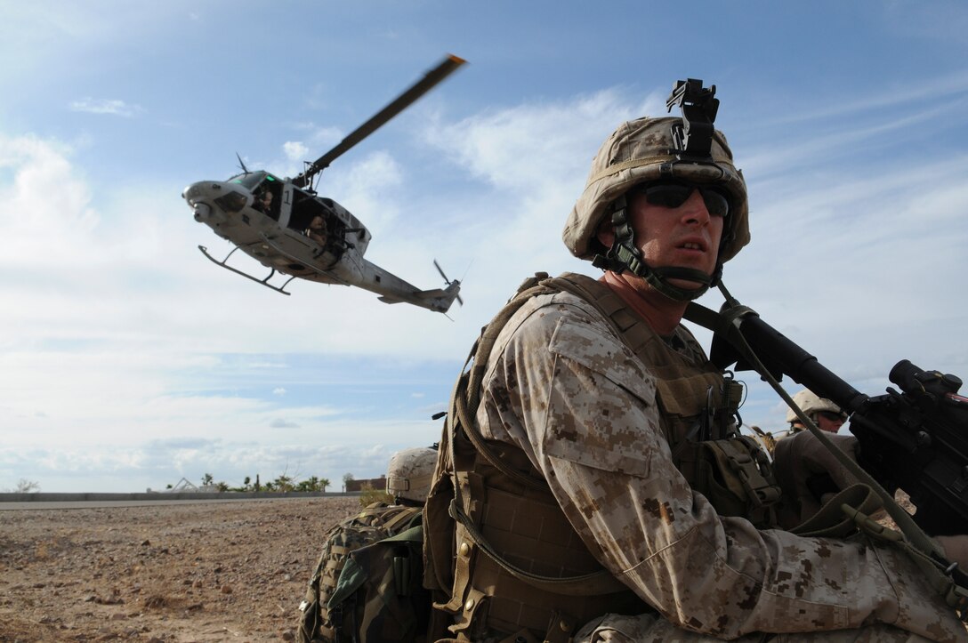 Lance Cpl. Mark W. Briggs, assaultman with E Company, 2nd Battalion, 7th Marine Regiment, waits to be extracted in UH-1 helicopters from an urban training range at the U.S. Army Yuma Proving Ground in Arizona during a helicopter raid exercise Oct. 12, 2009. Sixteen Marines landed on the outskirts of the range in four UH-1 helicopters and stormed the buildings from all sides searching for two insurgent leaders, simulating a mission they could be called to perform during their next deployment. The battalion, based in Twentynine Palms, Calif., is scheduled to deploy with the 31st Marine Expeditionary Unit in early 2010, with E Company assigned to specialize in helicopter insertions and raids. Briggs, 25, is a Salt Lake City native.