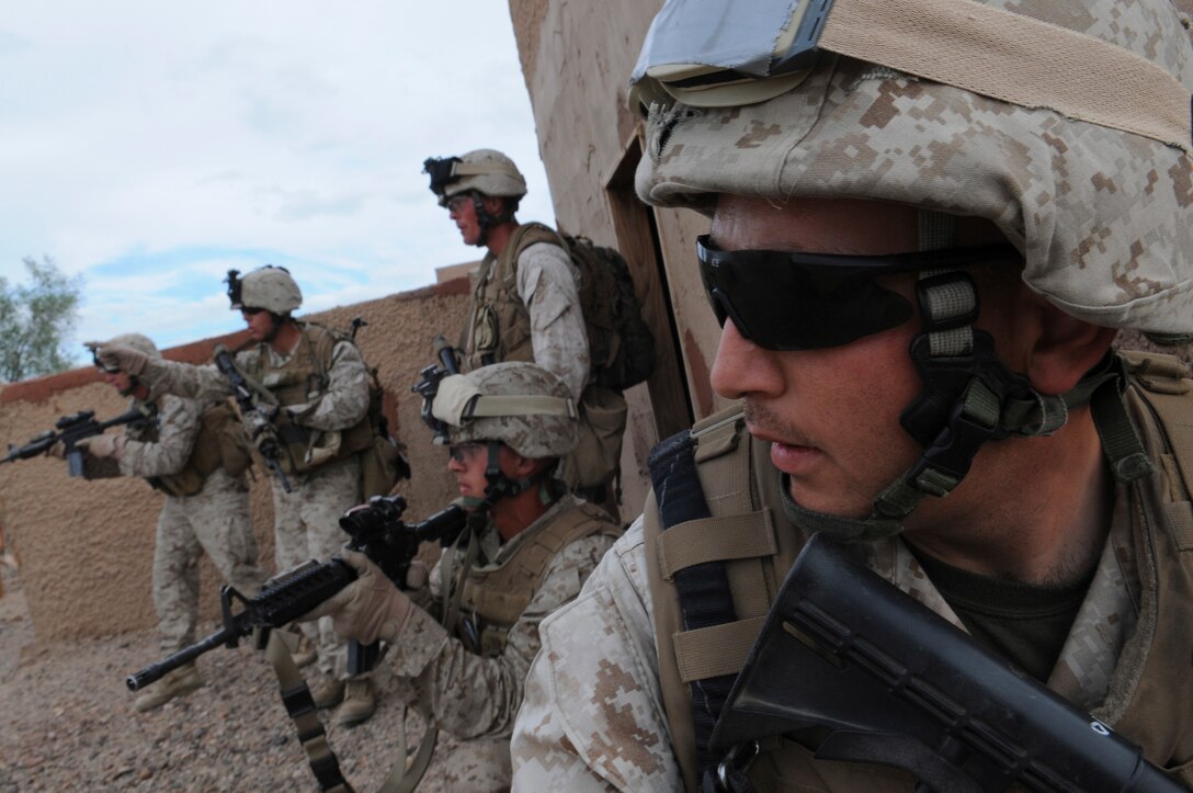 Sgt. Patrick R. Stephens, squad leader with E Company, 2nd Battalion, 7th Marine Regiment, halts members of his squad behind a wall before deciding his next move in an urban training range at the U.S. Army Yuma Proving Ground in Arizona during a helicopter raid exercise Oct. 12, 2009. Sixteen Marines landed on the outskirts of the range in four UH-1 helicopters and stormed the buildings from all sides searching for two insurgent leaders, simulating a mission they could be called to perform during their next deployment. The battalion, based in Twentynine Palms, Calif., is scheduled to deploy with the 31st Marine Expeditionary Unit in early 2010, with E Company assigned to specialize in helicopter insertions and raids. Stephens, 25, is a native of Austin, Texas. (Photo by Gunnery Sgt. Bill Lisbon)