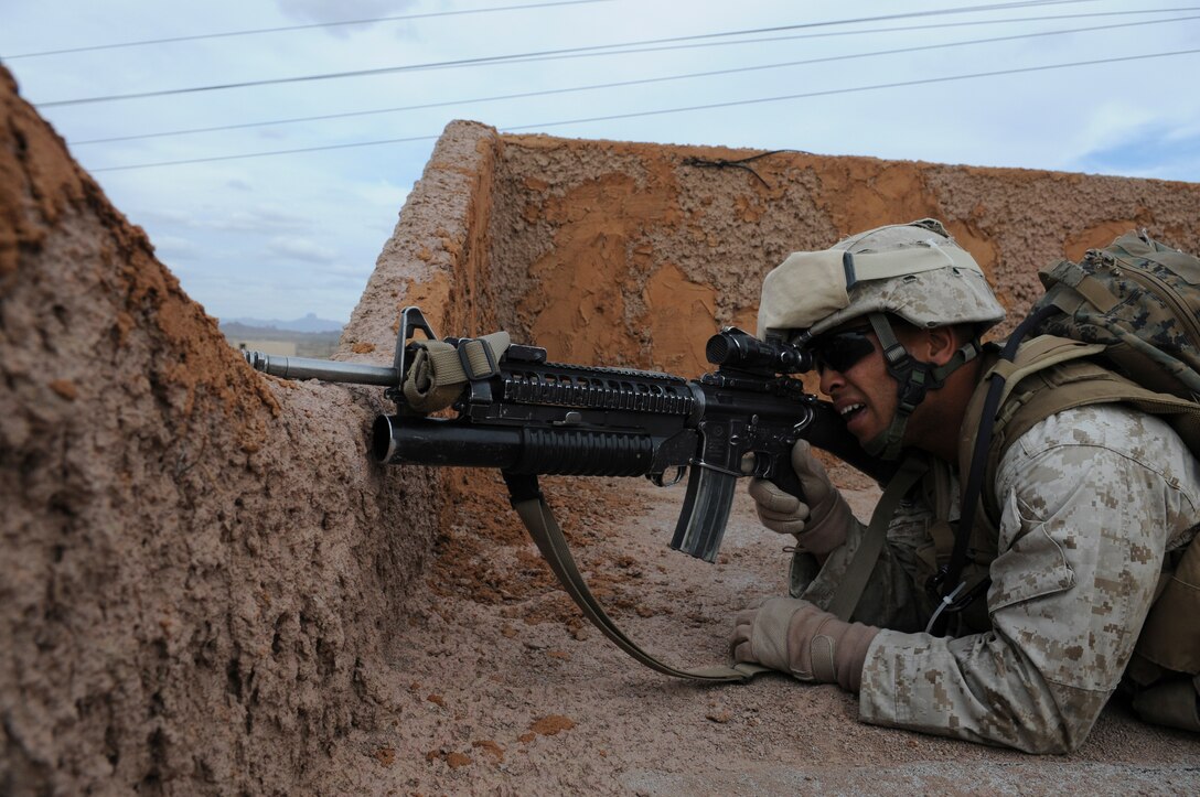 Lance Cpl. Carlos Batista, a rifle team leader with E Company, 2nd Battalion, 7th Marine Regiment, keeps watch for enemy on the roof of a building in an urban training range at the U.S. Army Yuma Proving Ground in Arizona during a helicopter raid exercise Oct. 12, 2009. Sixteen Marines landed on the outskirts of the range in four UH-1 helicopters and stormed the buildings from all sides searching for two insurgent leaders, simulating a mission they could be called to perform during their next deployment. The battalion, based in Twentynine Palms, Calif., is scheduled to deploy with the 31st Marine Expeditionary Unit in early 2010, with E Company assigned to specialize in helicopter insertions and raids. Batista, 20, is a Miami-native.