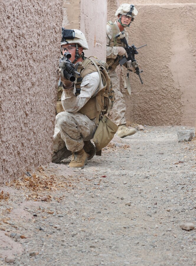 Lance Cpl. Tyler Steffins, left, and Lance Cpl. Matthew J. Huebsch, with E Company, 2nd Battalion, 7th Marine Regiment, keep watch on an alley in an urban training range at the U.S. Army Yuma Proving Ground in Arizona during a helicopter raid exercise Oct. 12, 2009. Sixteen Marines landed on the outskirts of the range in four UH-1 helicopters and stormed the buildings from all sides searching for two insurgent leaders, simulating a mission they could be called to perform during their next deployment. The battalion, based in Twentynine Palms, Calif., is scheduled to deploy with the 31st Marine Expeditionary Unit in early 2010, with E Company assigned to specialize in helicopter insertions and raids. Steffins, 21, is a native of Marysville, Wash., and Huebsch, 23, is a native of St. Ansgar, Iowa.