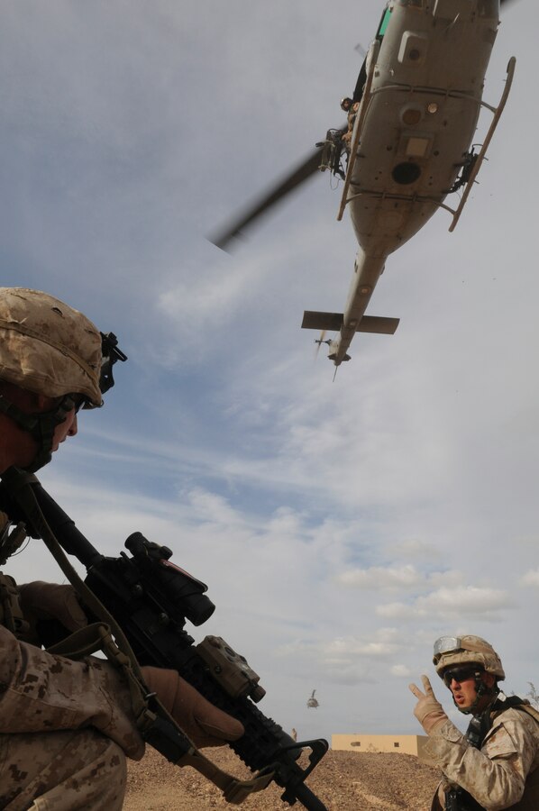 Sgt. Patrick R. Stephens, right, squad leader with E Company, 2nd Battalion, 7th Marine Regiment, signals Lance Cpl. Mark W. Briggs before extraction by in UH-1 helicopters from an urban training range at the U.S. Army Yuma Proving Ground in Arizona during a helicopter raid exercise Oct. 12, 2009. Sixteen Marines landed on the outskirts of the range in four UH-1 helicopters and stormed the buildings from all sides searching for two insurgent leaders, simulating a mission they could be called to perform during their next deployment. The battalion, based in Twentynine Palms, Calif., is scheduled to deploy with the 31st Marine Expeditionary Unit in early 2010, with E Company assigned to specialize in helicopter insertions and raids. Stephens, 25, is a native of Austin, Texas, and Briggs, 25, is a Salt Lake City native.