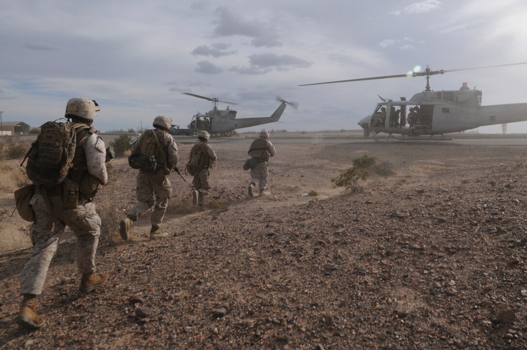 Members of E Company, 2nd Battalion, 7th Marine Regiment, move toward waiting UH-1 helicopters in order to be extracted from an urban training range at the U.S. Army Yuma Proving Ground in Arizona during a helicopter raid exercise Oct. 12, 2009. Sixteen Marines landed on the outskirts of the range in four UH-1 helicopters and stormed the buildings from all sides searching for two insurgent leaders, simulating a mission they could be called to perform during their next deployment. The battalion, based in Twentynine Palms, Calif., is scheduled to deploy with the 31st Marine Expeditionary Unit in early 2010, with E Company assigned to specialize in helicopter insertions and raids.