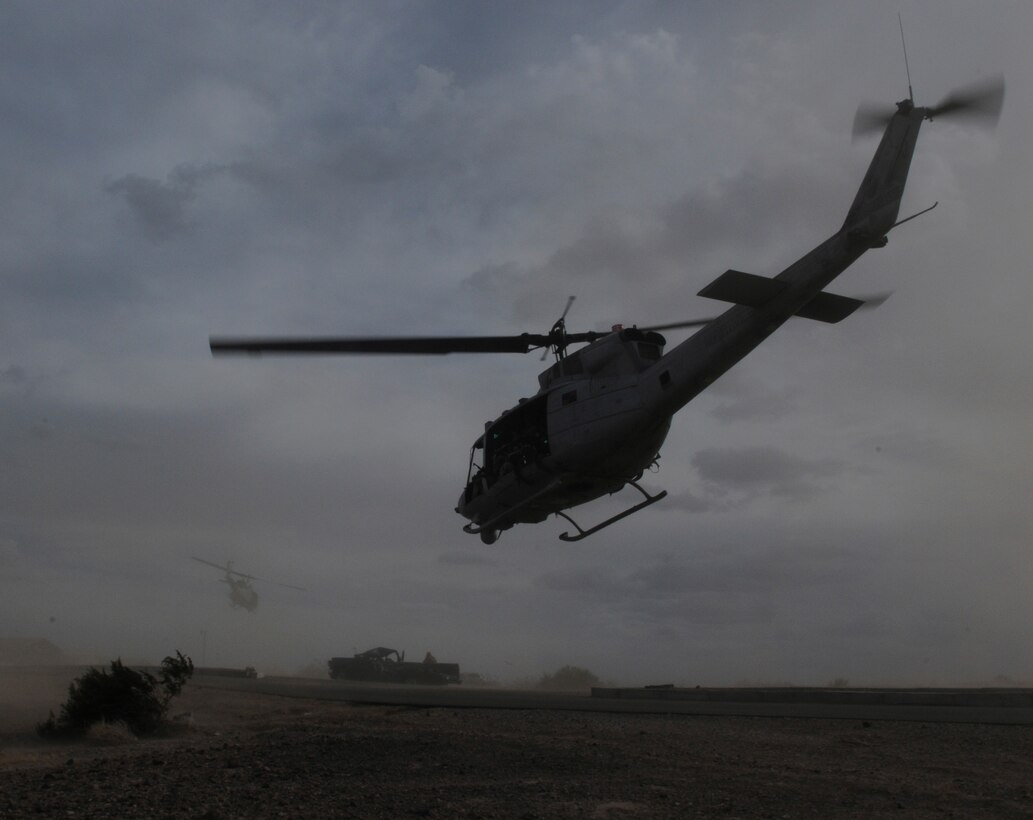 Two UH-1 helicopters carry members of E Company, 2nd Battalion, 7th Marine Regiment, from an urban training range at the U.S. Army Yuma Proving Ground in Arizona during a helicopter raid exercise Oct. 12, 2009. Sixteen Marines landed on the outskirts of the range in four UH-1 helicopters and stormed the buildings from all sides searching for two insurgent leaders, simulating a mission they could be called to perform during their next deployment. The battalion, based in Twentynine Palms, Calif., is scheduled to deploy with the 31st Marine Expeditionary Unit in early 2010, with E Company assigned to specialize in helicopter insertions and raids.
