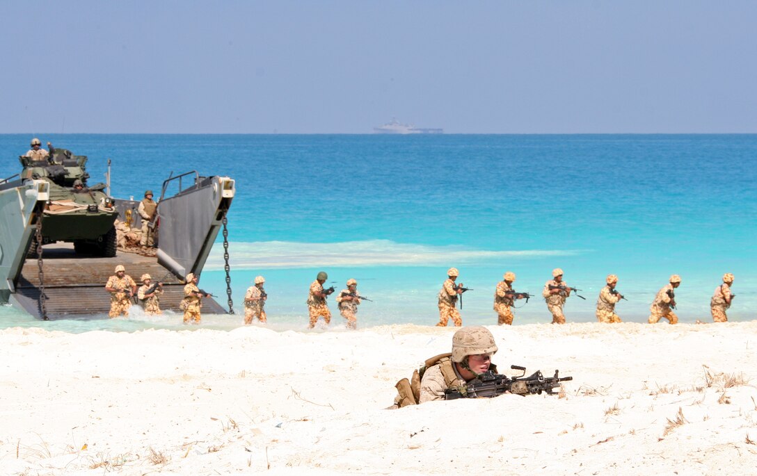 A U.S. Marine from 22nd Marine Expeditionary Unit (MEU) provides security for Kuwaiti Marines as they exit a landing craft utility (LCU) from Assault Craft Unit (ACU) 2 during an amphibious assault demonstration conducted as part of Bright Star 2009 in Egypt Oct. 12, 2009. The multinational exercise is designed to improve readiness, interoperability, strengthen the military and professional relationships among U.S., Egyptian and participating forces. Bright Star is conducted by U.S. Central Command and held every two years. Elements of the 22nd MEU are currently are participating in the multi-national exercise while serving as the theater reserve force for U.S. Central Command.::r::::n::(Official Marine Corps Photo by Cpl. Theodore W. Ritchie)::r::::n::