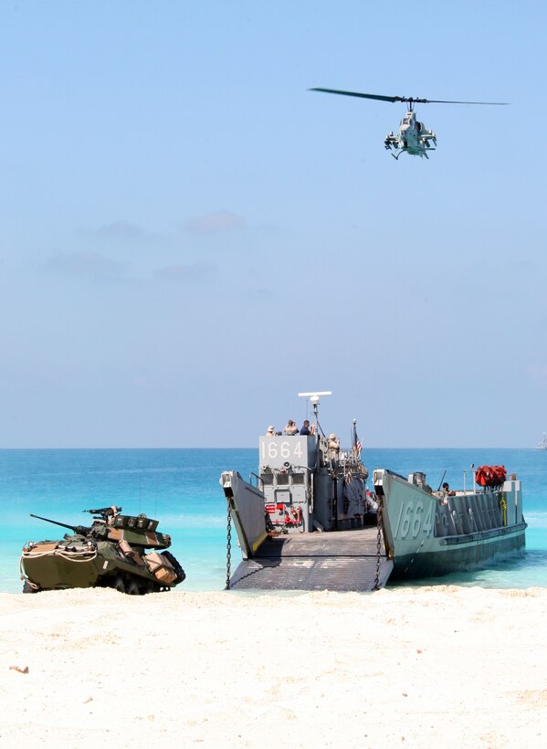 An AH-1W Super Cobra from Marine Medium Tiltrotor Squadron 263 (Reinforced), attached to the 22nd Marine Expeditionary Unit (MEU), provides close air-support as a light-armored vehicle from Weapons Company, Battalion Landing Team, 3rd Battalion, 2nd Marine Regiment, 22nd MEU, assaults the beach during an amphibious assault demonstration conducted as part of Bright Star 2009 in Egypt Oct. 12, 2009. The multinational exercise is designed to improve readiness, interoperability, strengthen the military and professional relationships among U.S., Egyptian and participating forces. Bright Star is conducted by U.S. Central Command and held every two years. Elements of the 22nd MEU are currently are participating in the multi-national exercise while serving as the theater reserve force for U.S. Central Command.::r::::n::(Official Marine Corps Photo by Cpl. Theodore W. Ritchie)::r::::n::