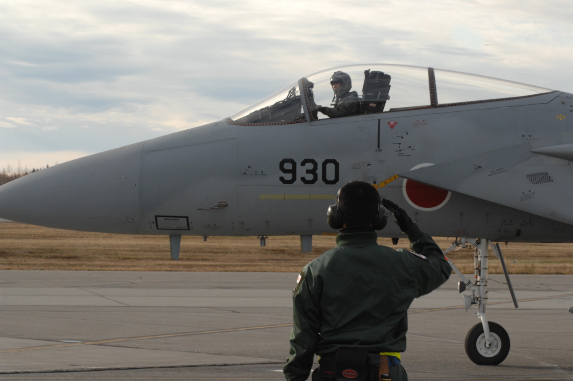 A Japan Air Self-Defense Force maintenance officer, Lt. Akira Orimoto, salutes an F-15 Eagle pilot during RED FLAG-Alaska 10-1, Oct. 8, 2009, Eielson Air Force Base, Alaska. RF-A provides participants 67,000 square miles of airspace, more than 30 threat simulators, one conventional bombing range and two tactical bombing ranges containing more than 400 different types of targets. (U.S. Air Force photo/Airman 1st Class Rachelle Coleman)