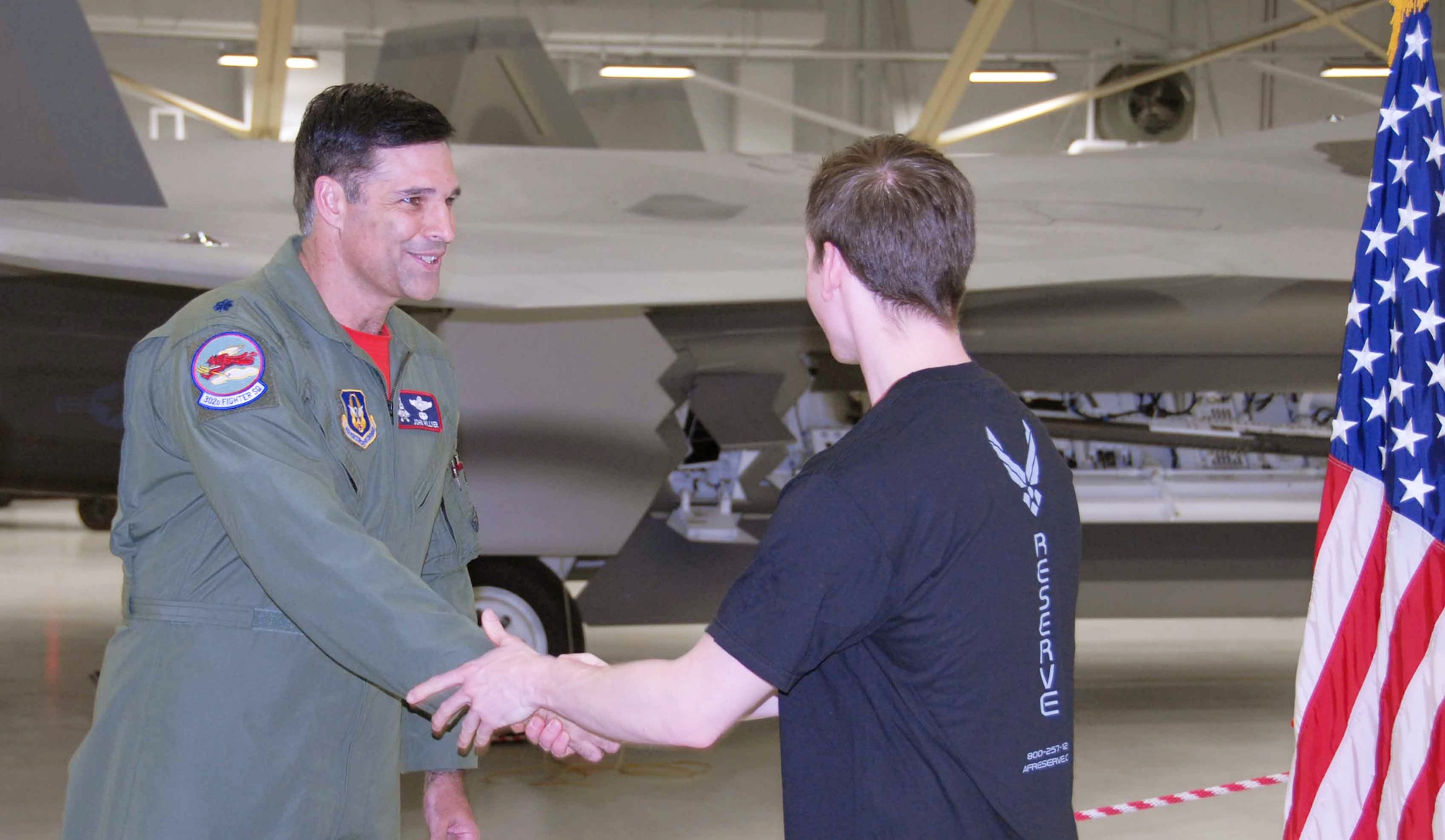 Lt. Col. Hillyer, Commander, 477th Fighter Group congratulates Staff Sgt. Joel Ainsworth on his enlistment in the Air Force Reserve.  Staff Sgt. Ainsworth enlisted as Traditional Reservist to become the 477th FG's only Paralegal Assistant.  Traditional Reservists are Citizen Airmen who serve one weekend a month, two weeks a year.  Currently there are approximately 240 people assigned to the 477th Fighter Group.  Recruiting efforts are on-going to achieve their goal to have 425 Citizen Airmen by 2012.  The 477th Fighter Group is Air Force Reserve command's first F-22 Raptor unit and the first Reserve flying unit based in the Pacific theater of operations.  The Group is a Classic Associate unit responsible for recruiting, training, developing and retaining Citizen Airmen to support Expeditionary Air Force mission requirements. (Air Force Photo/Maj. Cary McPartlin)