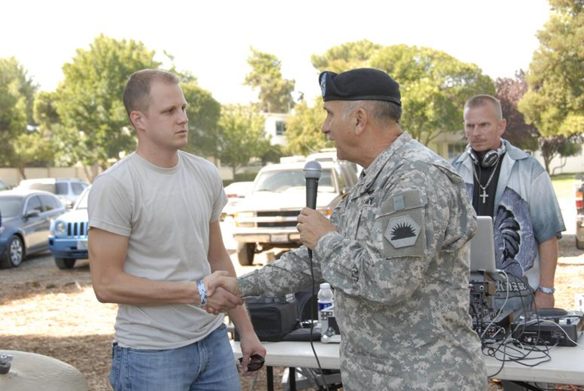 Maj. Gen. William H. Wade, the California Adjutant General, congratulates Senior Airman James Parmentier, a guidance and control systems avionics technician with the 129th Aircraft Maintenance Squadron, at the 129th Rescue Wing’s annual Family Day Picnic hosted Oct. 3 at Moffett Federal Airfield, Calif. for winning the John L. Levitow award for his accomplishments at Airman Leadership School. (Air National Guard photo by Tech. Sgt. Ray Aquino)