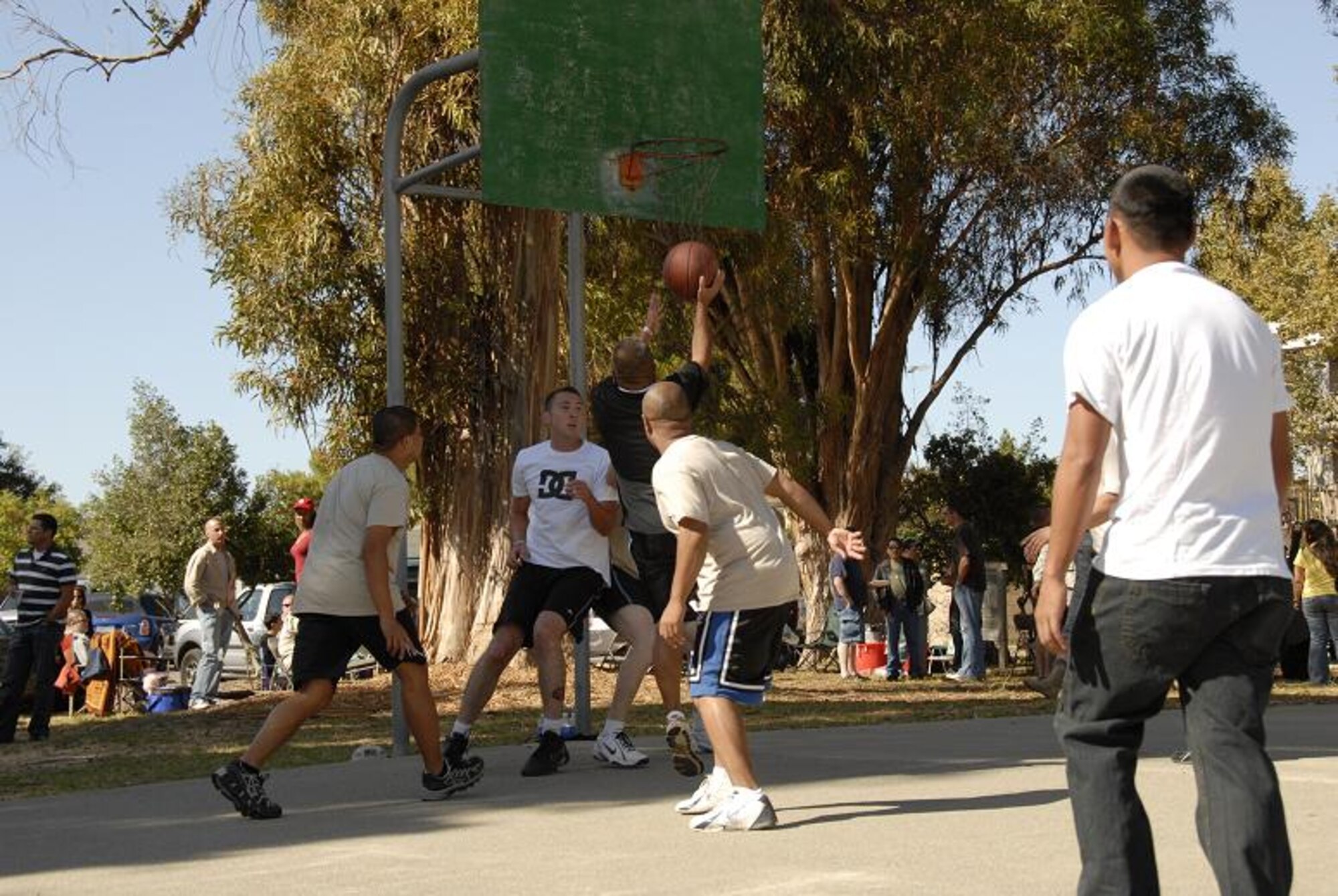 129th Rescue Wing Guardsmen, friends and family members play a game of pickup basketball while at the annual Family Day Picnic hosted Oct. 3 at Moffett Federal Airfield, Calif. (Air National Guard photo by Tech. Sgt. Ray Aquino)