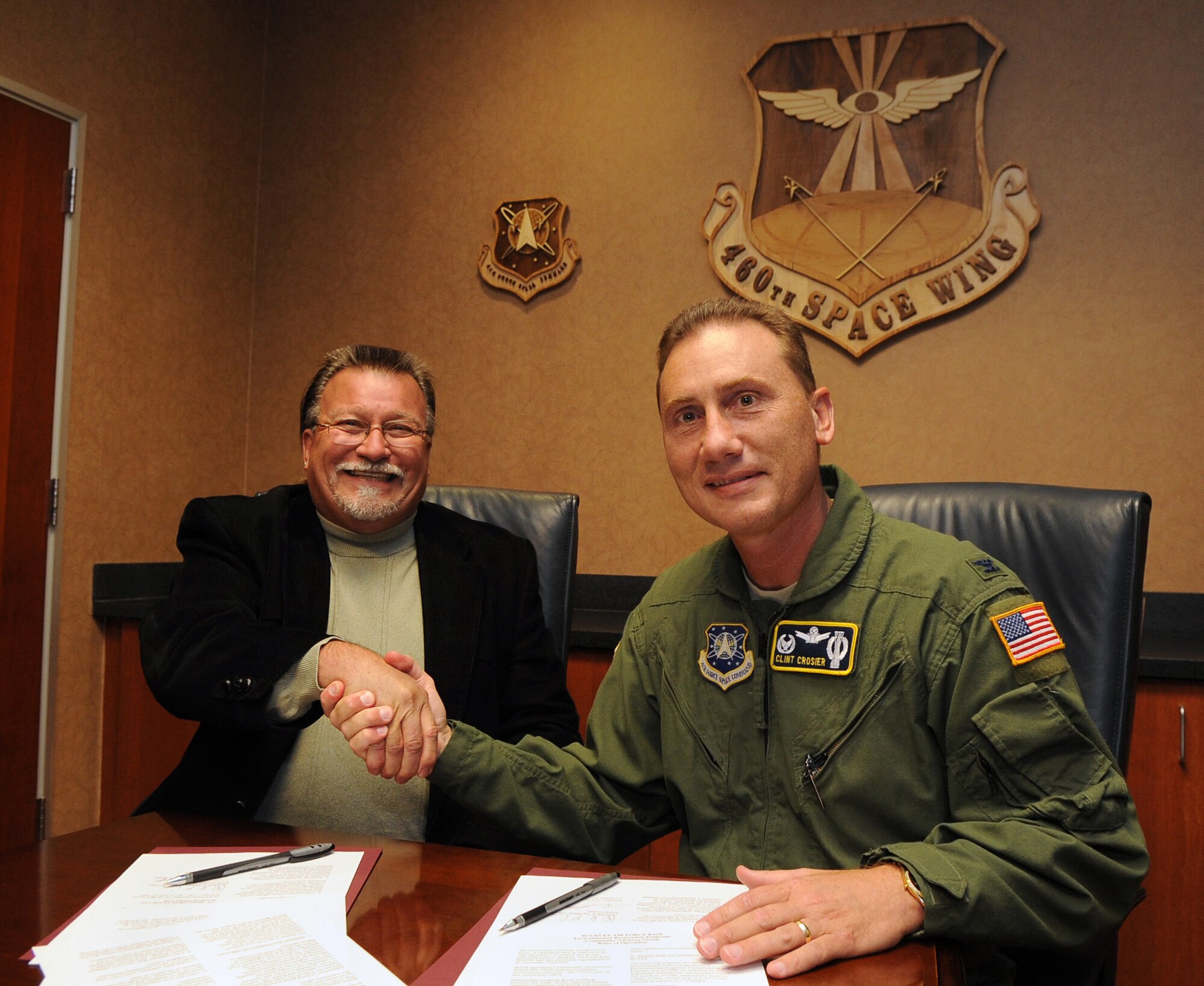 Buckley Air Force Base, Colo. -- Russell Clayshulte and Col. Clint Crosier, 460th Space Wing commander, sign the Buckley Air Force Base Community Advisory Group charter, Oct. 13.  The CAG is made up of base, community members, local, state and federal regulators who work toward environmental cleanup of the base. Mr. Clayshulte has been the CAG co-chair with five previous installation commanders at Buckley. (U.S. Air Force photo by Senior Airman John Easterling)