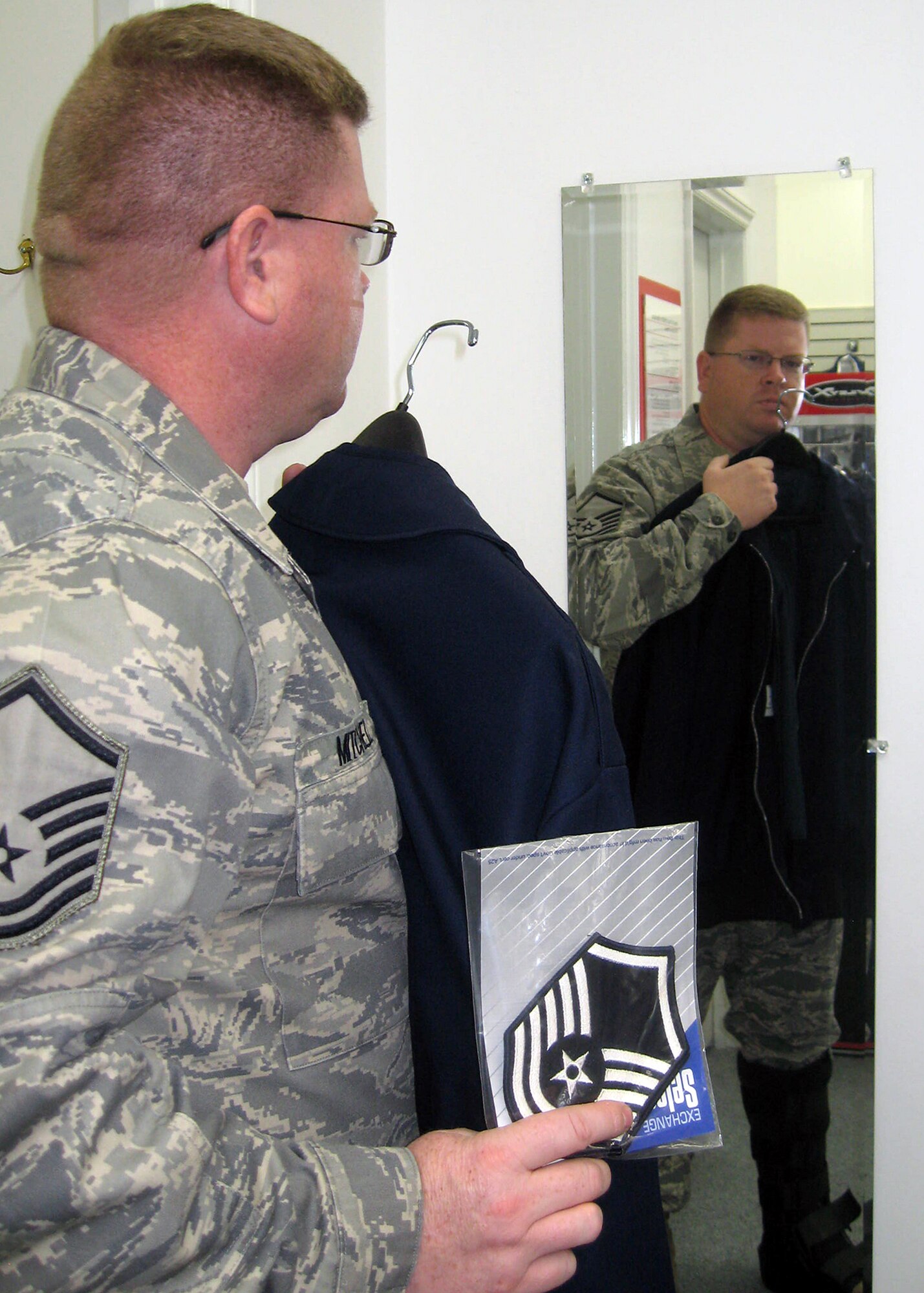 Master Sgt. Don Mitchell, 4th Equipment Maintenance Squadron assistant maintenance flight chief, checks the length of a light-weight jacket in the mirror at the Army and Air Force Exchange Military Clothing Sales Store Oct. 13, 2009. Enlisted Airmen must have chevron rank insignias sewn-on their light-weight jacket by effective Jan. 1, 2010. (U.S. Air Force photo/Tech. Sgt. Tammie Moore)
