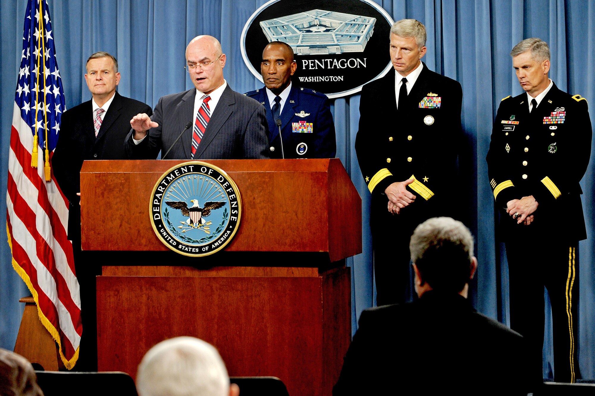 Deputy Under Secretary of Defense for Military Personnel Policy Bill Carr discusses armed forces recruiting and retention statistics at the Pentagon, Oct. 13, 2009. In the background, left to right, are: Michael S. Applegate, deputy director for Marine Corps Manpower and Reserve Affairs; Brig. Gen. A.J. Stewart, commander, Air Force Recruiting Service; Rear Adm. Craig Faller, commander, Navy Recruiting Command, and Maj. Gen. Donald Campbell, commander, Army Recruiting Command.  (DoD photo/R. D. Ward) 