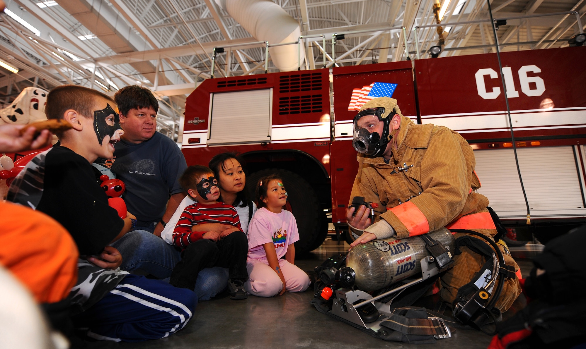 OFFUTT AIR FORCE BASE, Neb. - Mark French, an Offutt firefighter, demonstrates how firefighting gear works to a group of children attending Offutt Firehouse's Open House held Oct. 10.  National Fire Prevention Week starts on the first Sunday in October and ends the following Saturday, which is also Fire Service Recognition Day.  U.S. Air Force Photo by Josh Plueger