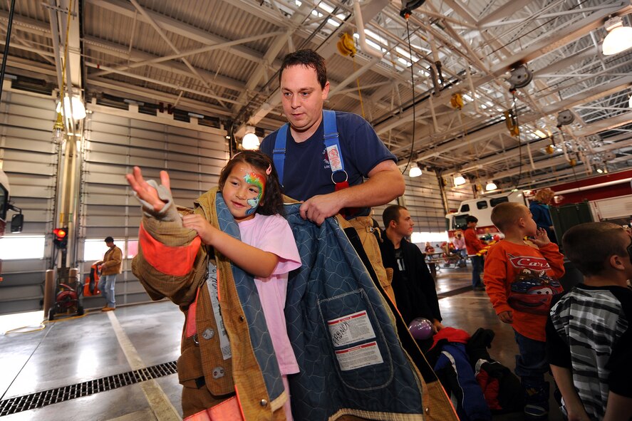 OFFUTT AIR FORCE BASE Neb. - Six year old Rachael Atwood, daughter of Ted Atwood U. S. Strategic Command, gets a chance to try on some authentic fire fighting gear with the assistance of Mark French, Offutt firefighter, Oct. 10.  The National Fire Prevention Week is observed in the United States, beginning on the first Sunday in October and ending the following Saturday, which is also designated Fire Service Recognition Day.  

U.S. Air Force Photo by Josh Plueger
