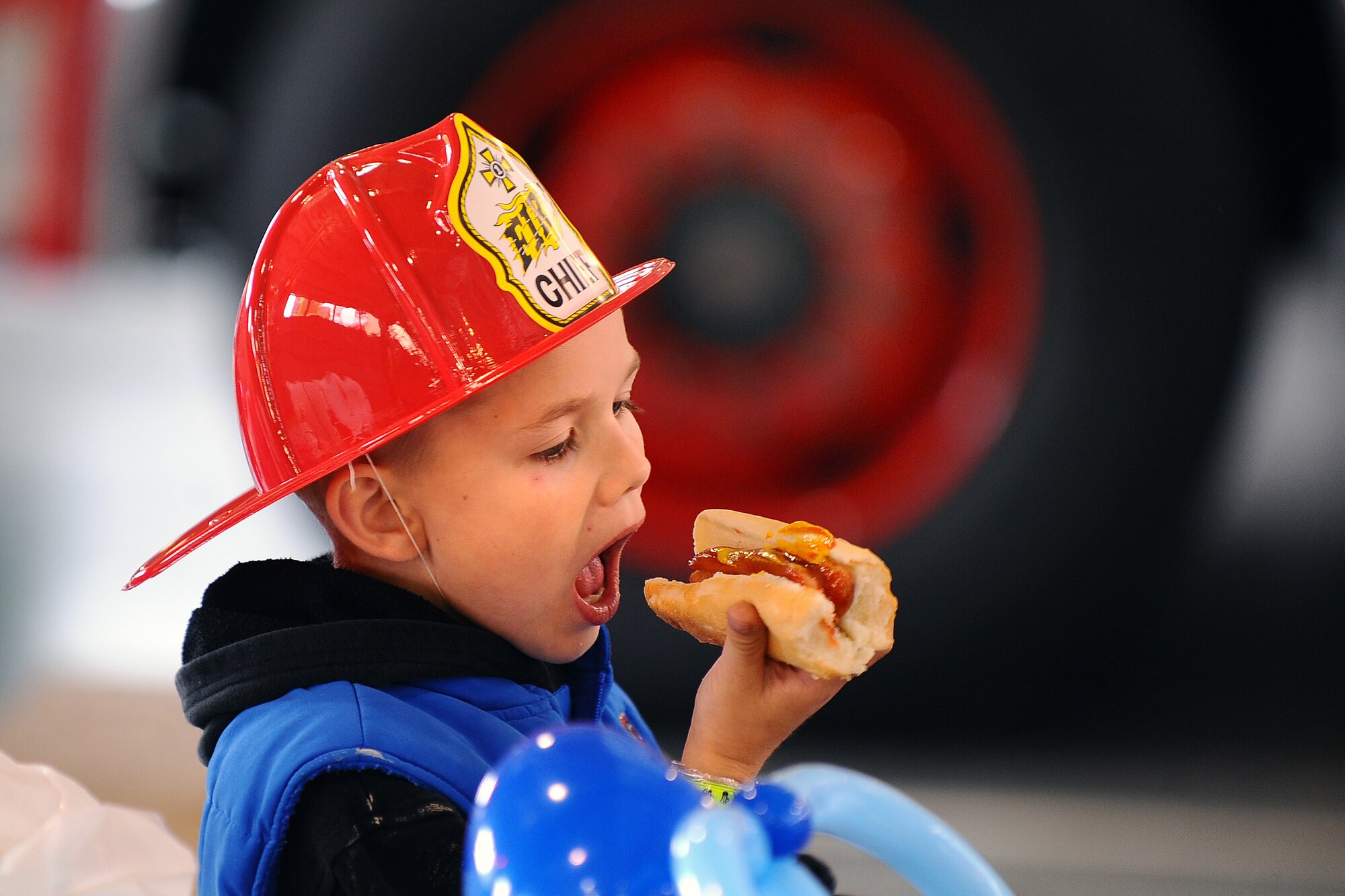 OFFUTT AIR FORCE BASE, Neb. - Seven-year-old Aarie Raabe, son of Tech. Sgt. Glenn Raabe with the 97th Intelligence Squadron, chows down on a hot dog while attending the Offutt Firehouse's Open House held Oct. 10.  National Fire Prevention Week starts on the first Sunday in October and ends the following Saturday, which is also Fire Service Recognition Day.  U.S. Air Force Photo by Josh Plueger