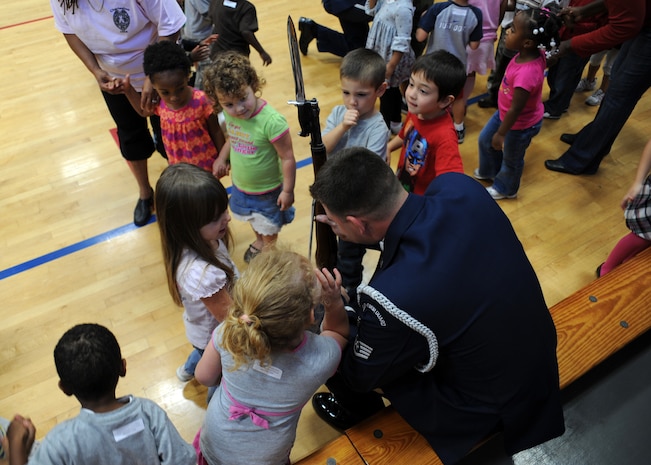 Staff Sgt. Adam Clonick meets with children at the Fitness and Sports Center here Oct. 9 after performing with the Air Force Honor Guard Drill Team. Team members met with those in the audience after performing to answer questions and sign autographs. (U.S. Air Force photo/Senior Airman Katie Gieratz)