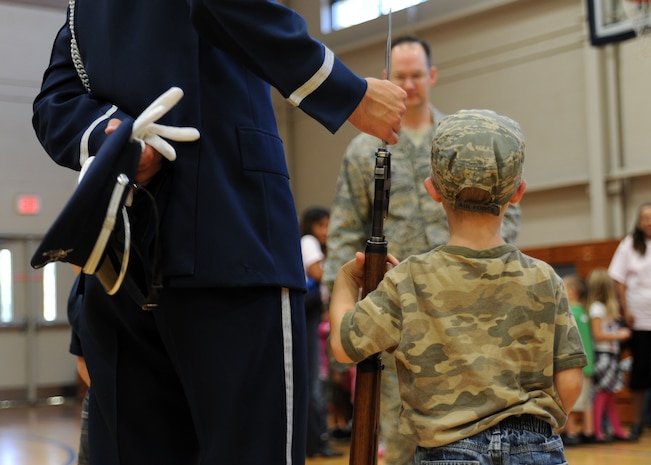 John Banks meets an Air Force Honor Guard Drill Team member at the Fitness and Sports Center here Oct. 9. The team is the traveling component of the Air Force Honor Guard and inspires Air Force awareness among military and civilian audiences through its complex drill routine. John is the son of Master Sgt. Jeramie Banks who is with the 437th Maintenance Squadron. (U.S. Air Force photo/Senior Airman Katie Gieratz)