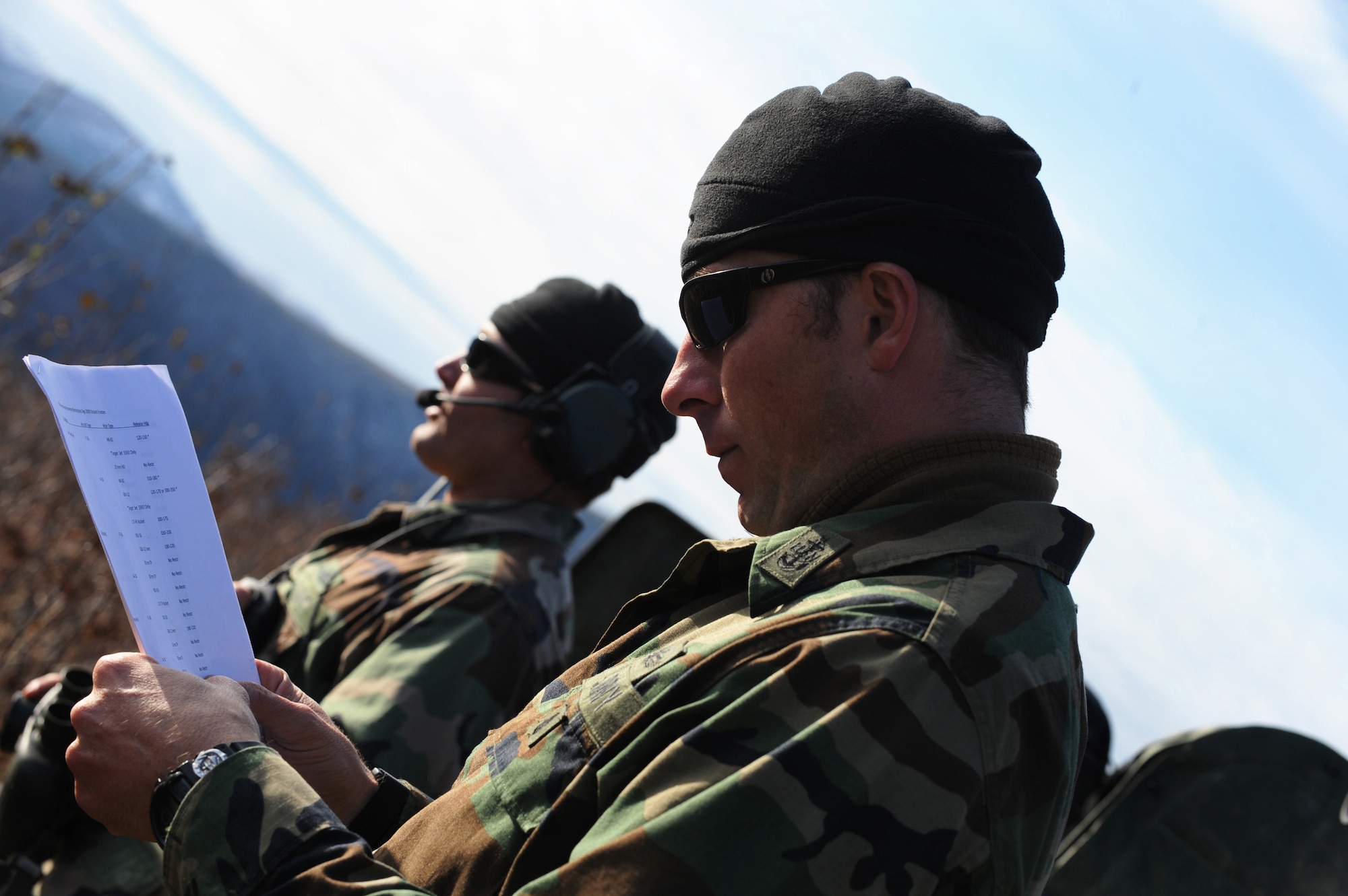 Navy Senior Chief Petty Officer Bruce Diette reviews an exercise schedule while Petty Officer 1st Class Nathan Crossett communicates with an F-16 Fighting Falcon pilot during RED FLAG-Alaska 10-1 Oct. 7, 2009, Eielson Air Force Base, Alaska. The Joint Pacific Alaskan Range Complex provides 67,000 square miles of airspace, more than 30 threat simulators, one conventional bombing range and two tactical bombing ranges containing more than 400 different types of targets. Petty Officers Crossett and Diette are Joint Terminal Air Controllers assigned to the Naval Amphibious Base Little Creek, Virginia. (U.S. Air Force photo/Airman 1st Class Laura Goodgame)