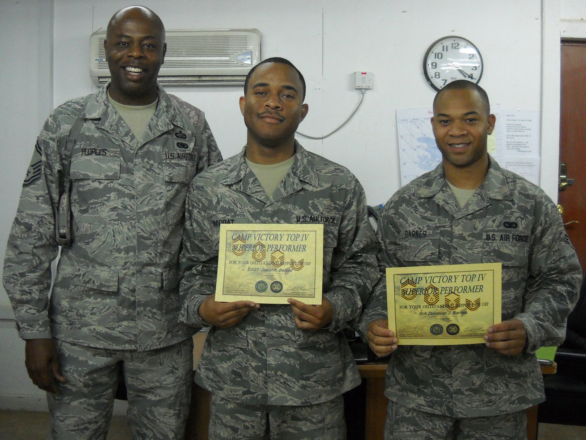 Senior Master Sgt. William Peoples (left), Victory Base Complex Top IV president, presents Staff Sgt. Jason Becoat and Senior Airman Donovan Barnes (right), letters of appreciation and a Top IV coin for their sustained superior performance and contribution to Operation Iraqi Freedom. Sergeant Becoat is deployed from Lackland AFB, Texas, and Airman Barnes is an administrative specialist deployed from the 21st Communications Squadron at Peterson. (Air Force photo)