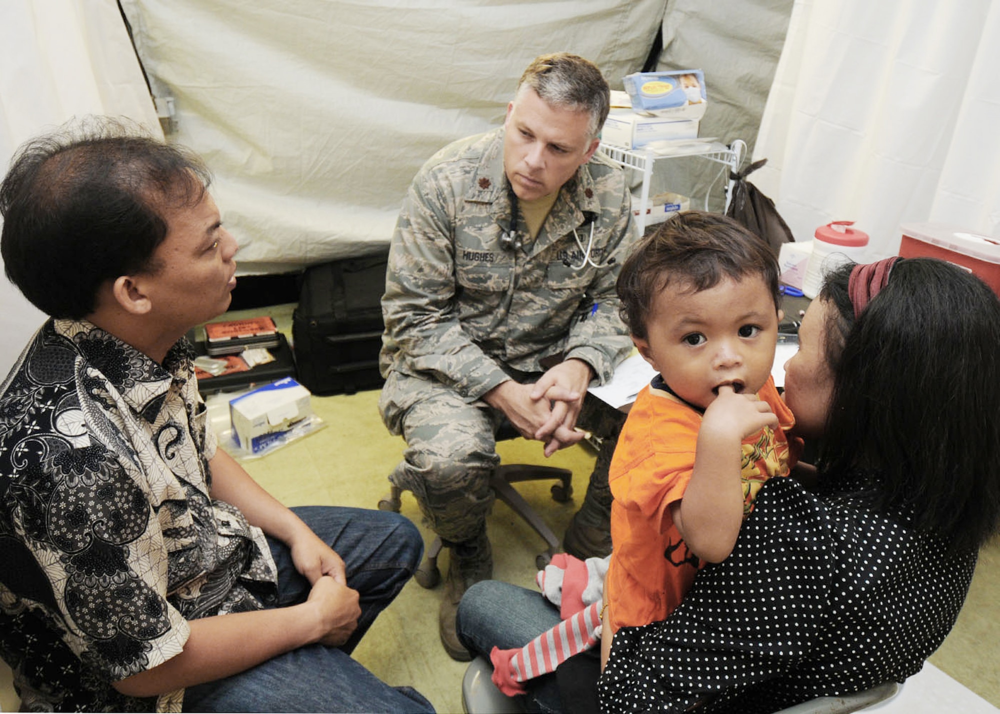 Maj. Scott Hughes gathers medical information from a patient with the help of Hasbi, a local interpreter, Oct. 10, 2009, in Padang, Indonesia. Major Hughes is a doctor from the 36th Medical Group at Andersen Air Force Base, Guam, and is deployed here with a U.S. Air Force humanitarian assistance rapid response team to provide medical assistance to those affected by the recent earthquakes. (U.S. Air Force photo/Staff Sgt. Veronica Pierce) 