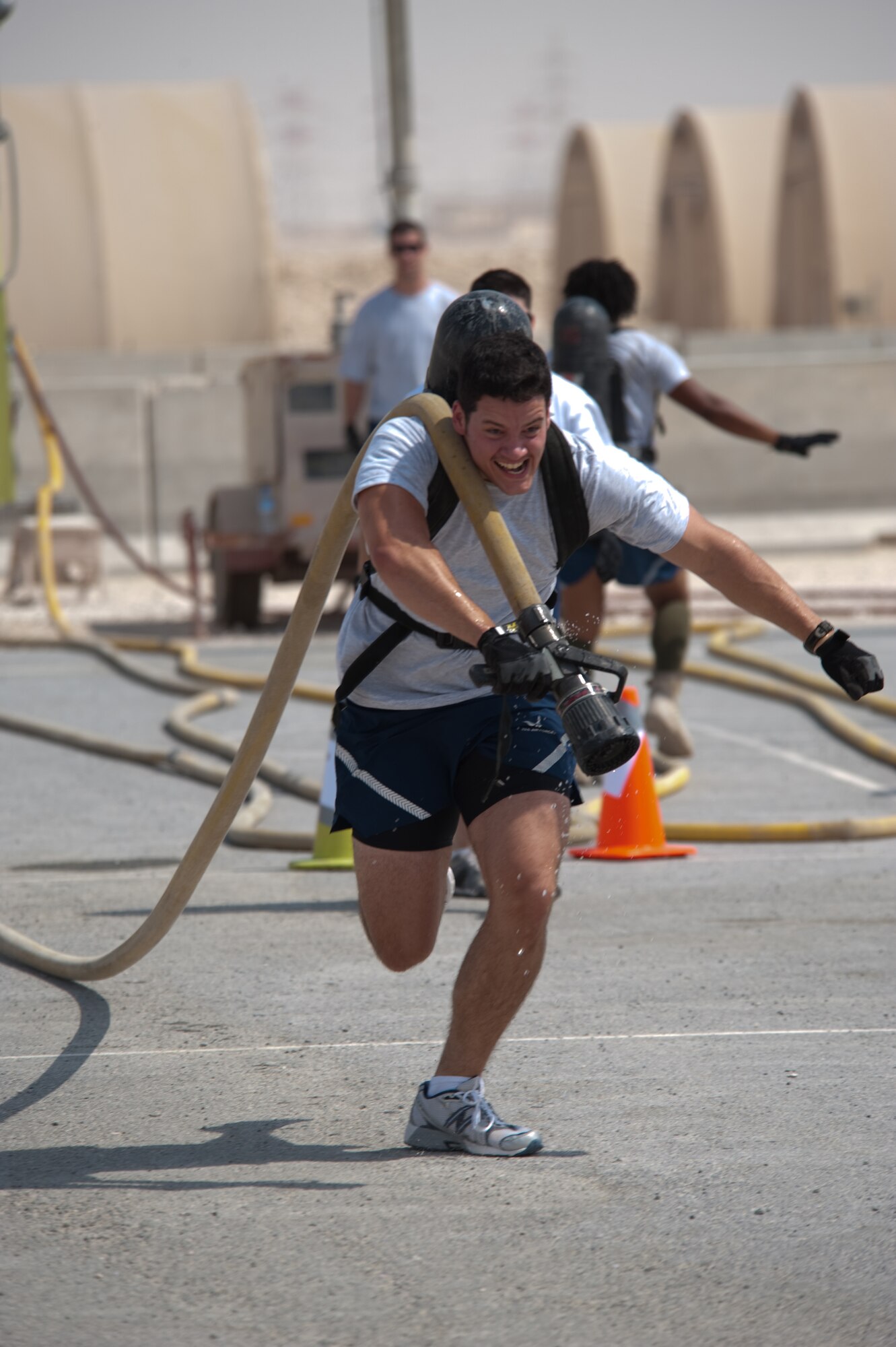 Airman 1st Class Matt Wojciechowski, 379th Expeditionary Civil Engineer squadron, competes in the hose spray event during a fire muster competition, Oct. 11, 2009, in Southwest Asia. The 379th Civil Engineer squadron Fire Department concluded fire safety week here with a muster that simulated multiple events and exercises firefighters perform on a regular basis. (U.S. Air Force photo/Staff Sgt. Robert Barney)